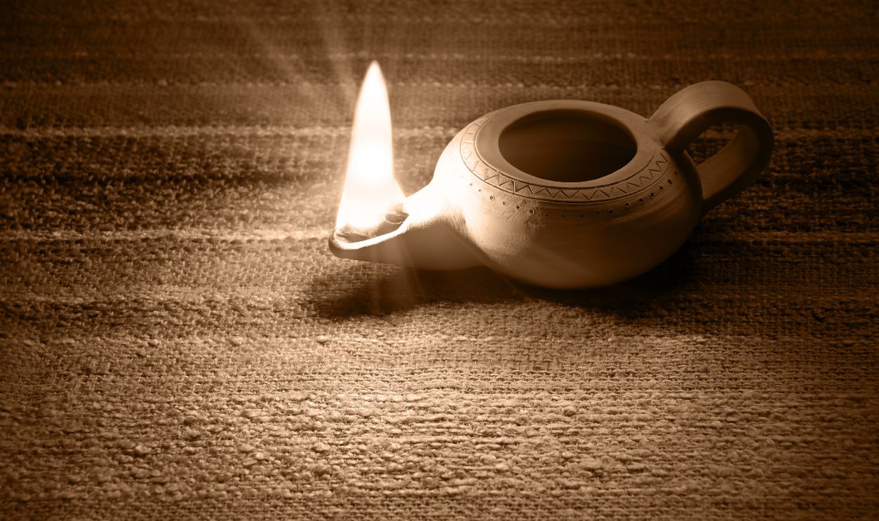 Closeup classic rural art middle arabian shiny kerosene jug jar vase burner wick blow table text space. Close up holy hand magic arab rustic past age biblic Jesus Christ faith pray design decor style