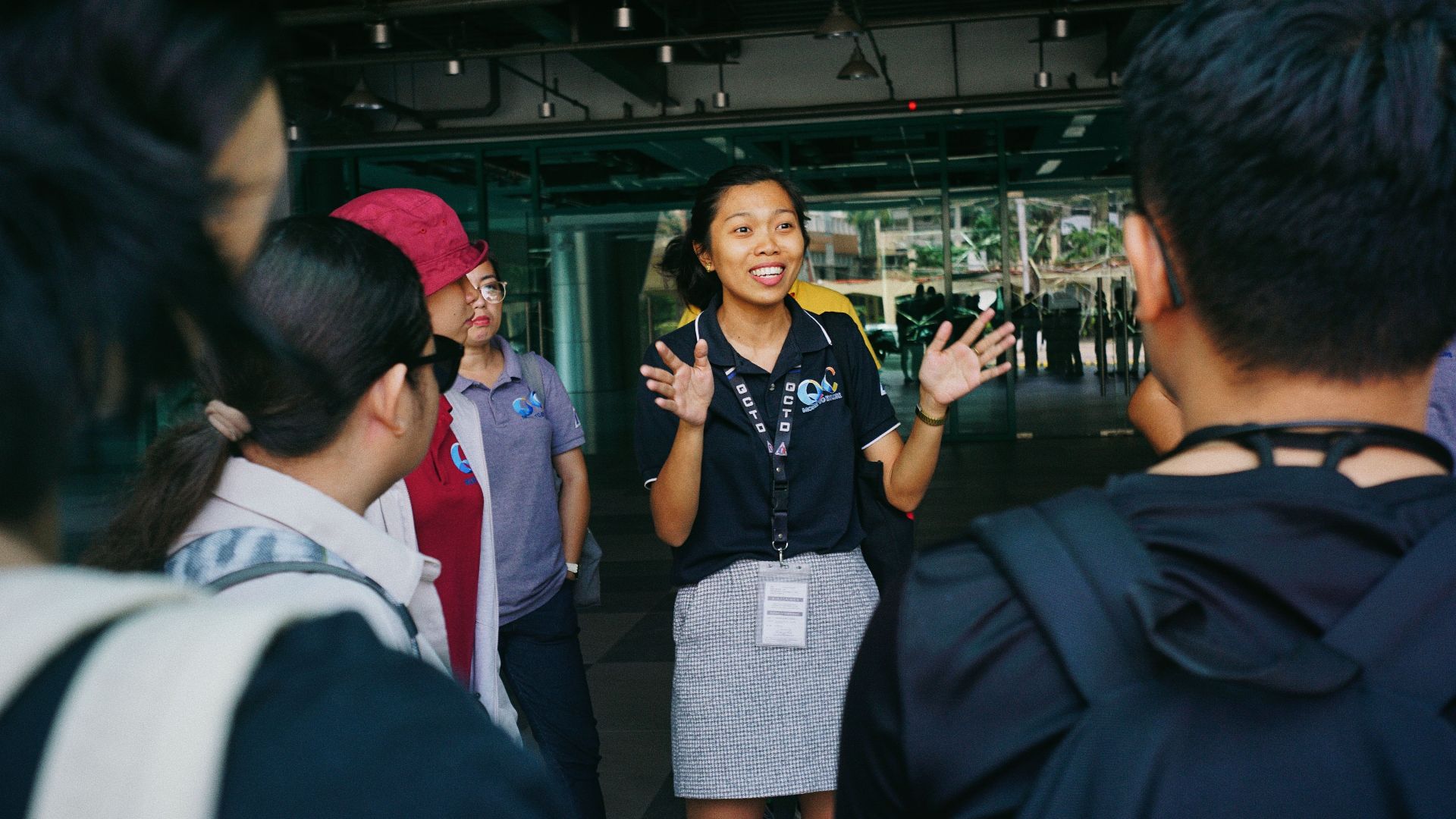 Tour guide leading a group tour, engaging visitors with gestures in an outdoor urban setting.