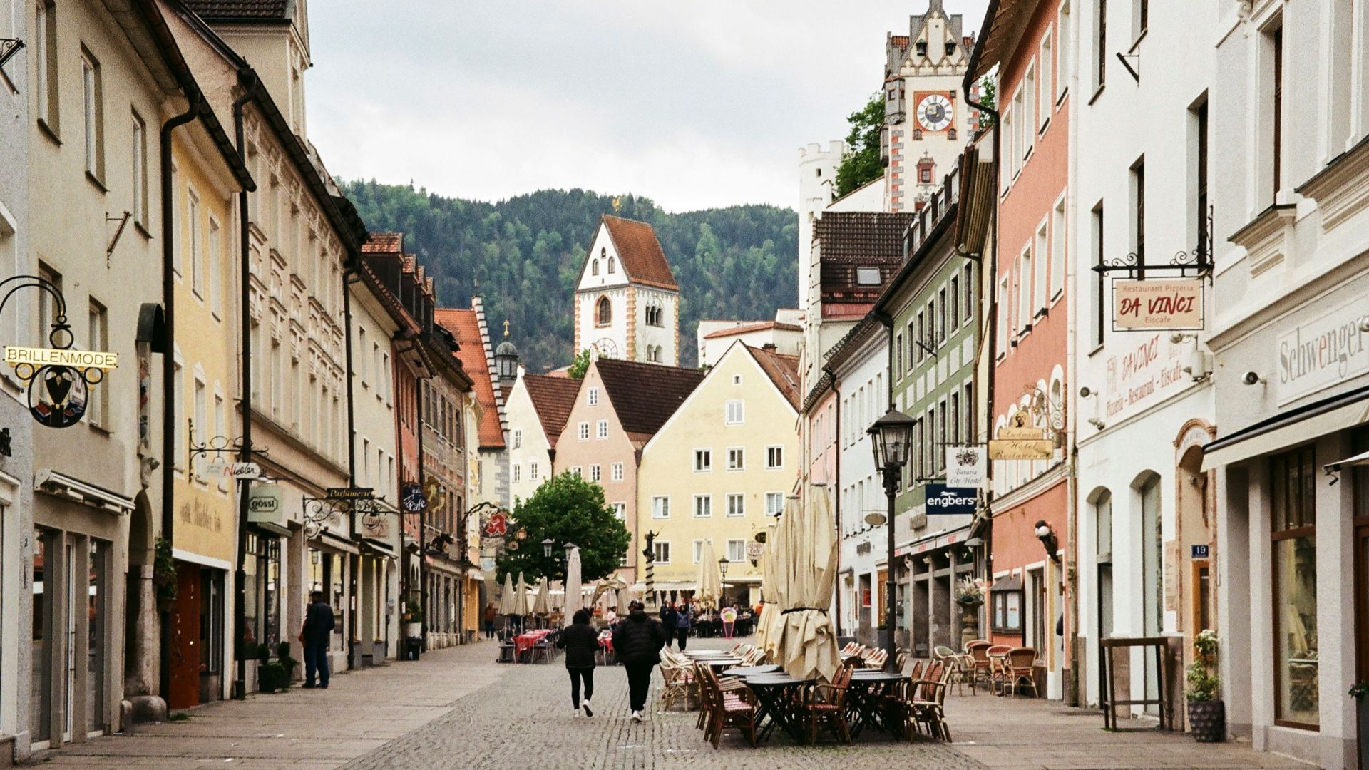 Picturesque street in Füssen, Bavaria with colorful buildings and cobblestone path.