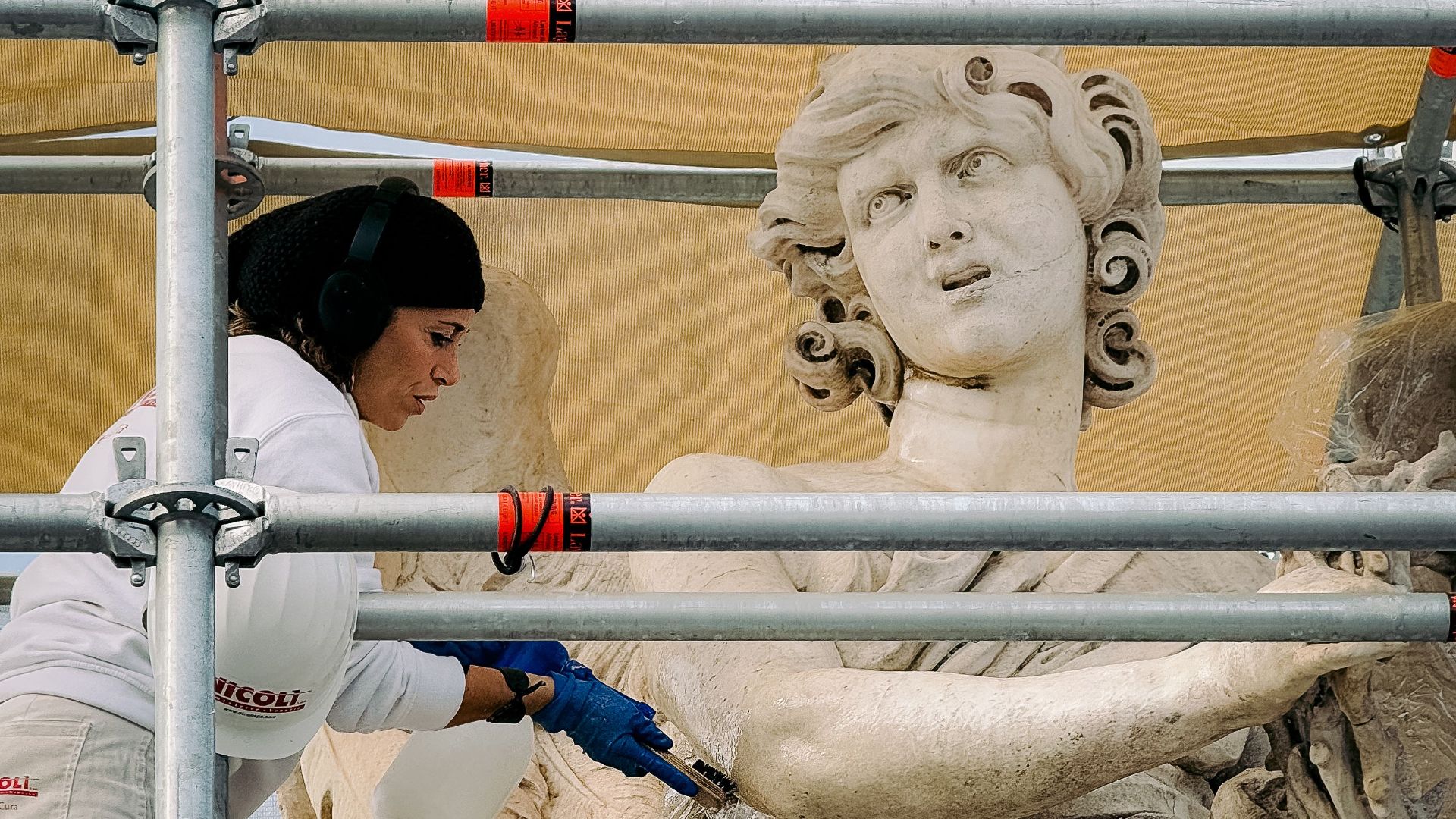 A conservationist meticulously restores an ancient statue in Rome, showcasing art preservation.