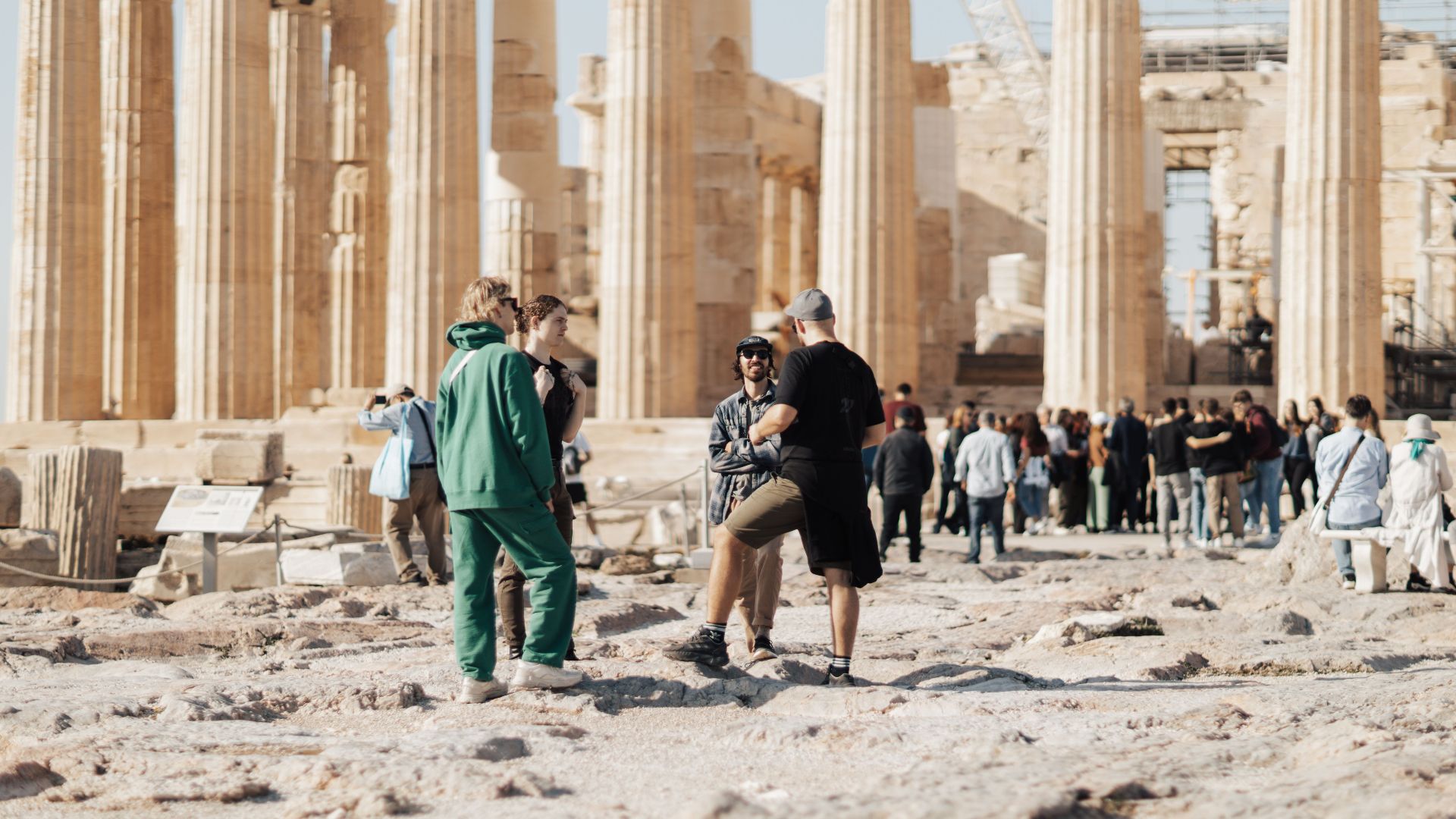 A group of tourists exploring the ancient ruins of the Parthenon in Athens, Greece.