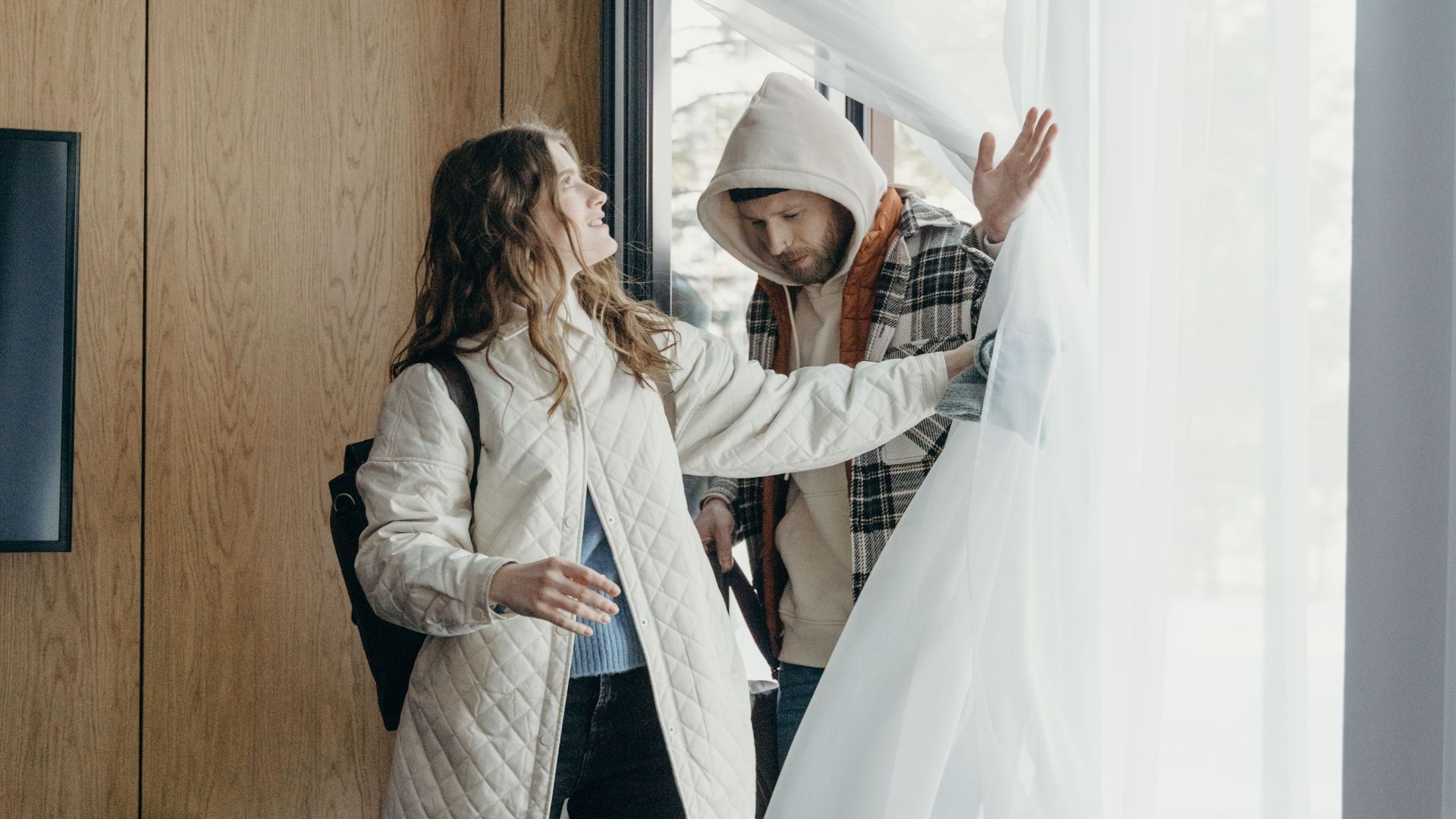 A couple enjoys a cozy moment in a winter cabin, embracing relaxation indoors.