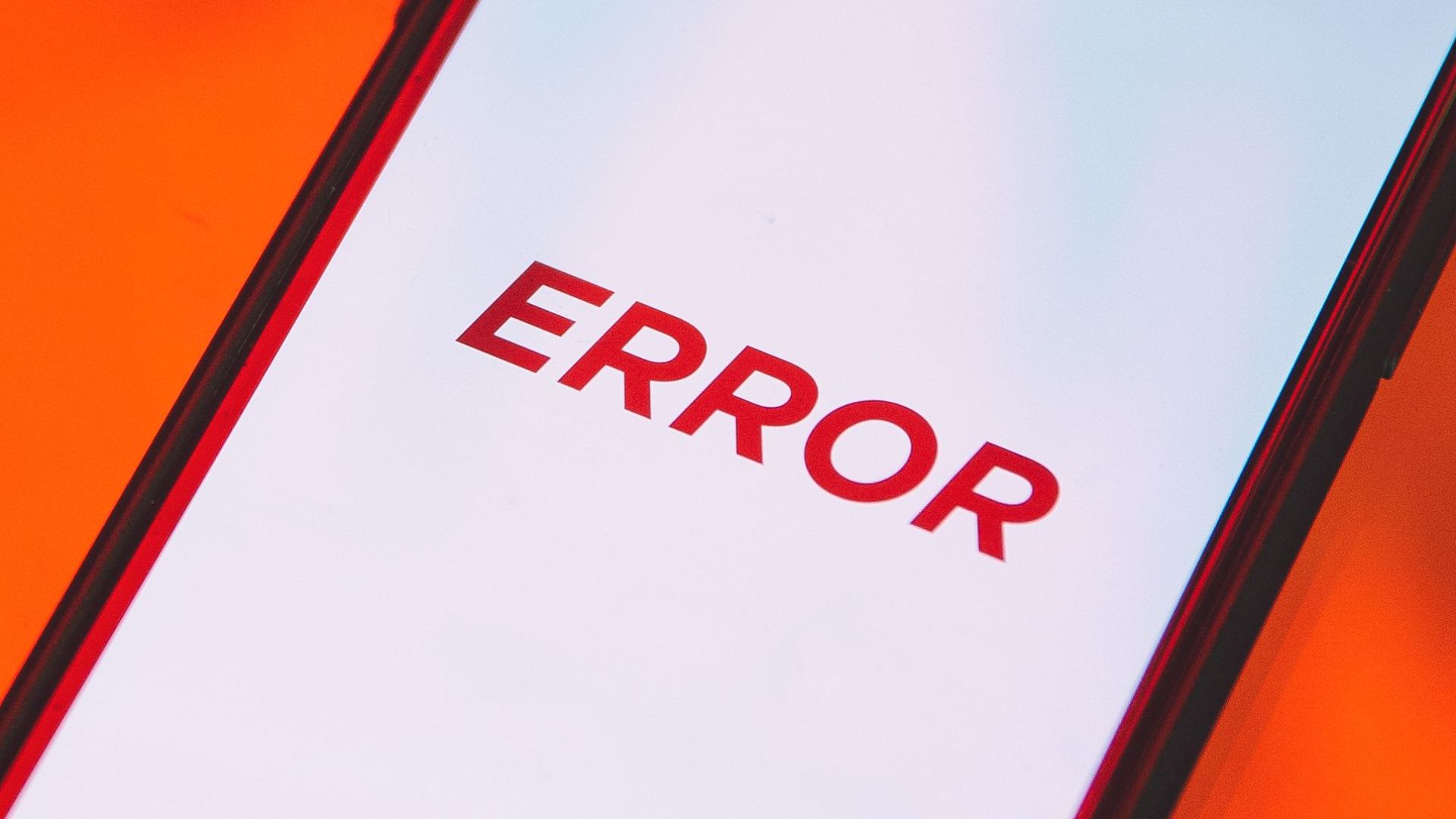 Smartphone displaying an error message on a vibrant red surface.
