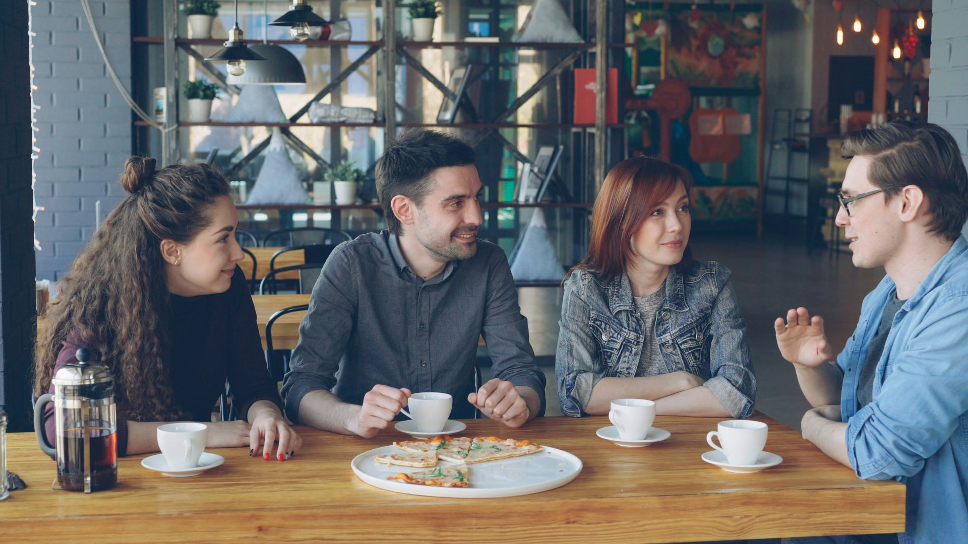 Friends chat and enjoy coffee at a cafe.