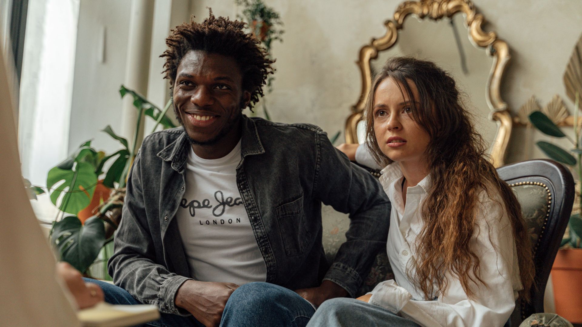 Couple engaged in therapy consultation, sitting on a sofa indoors.