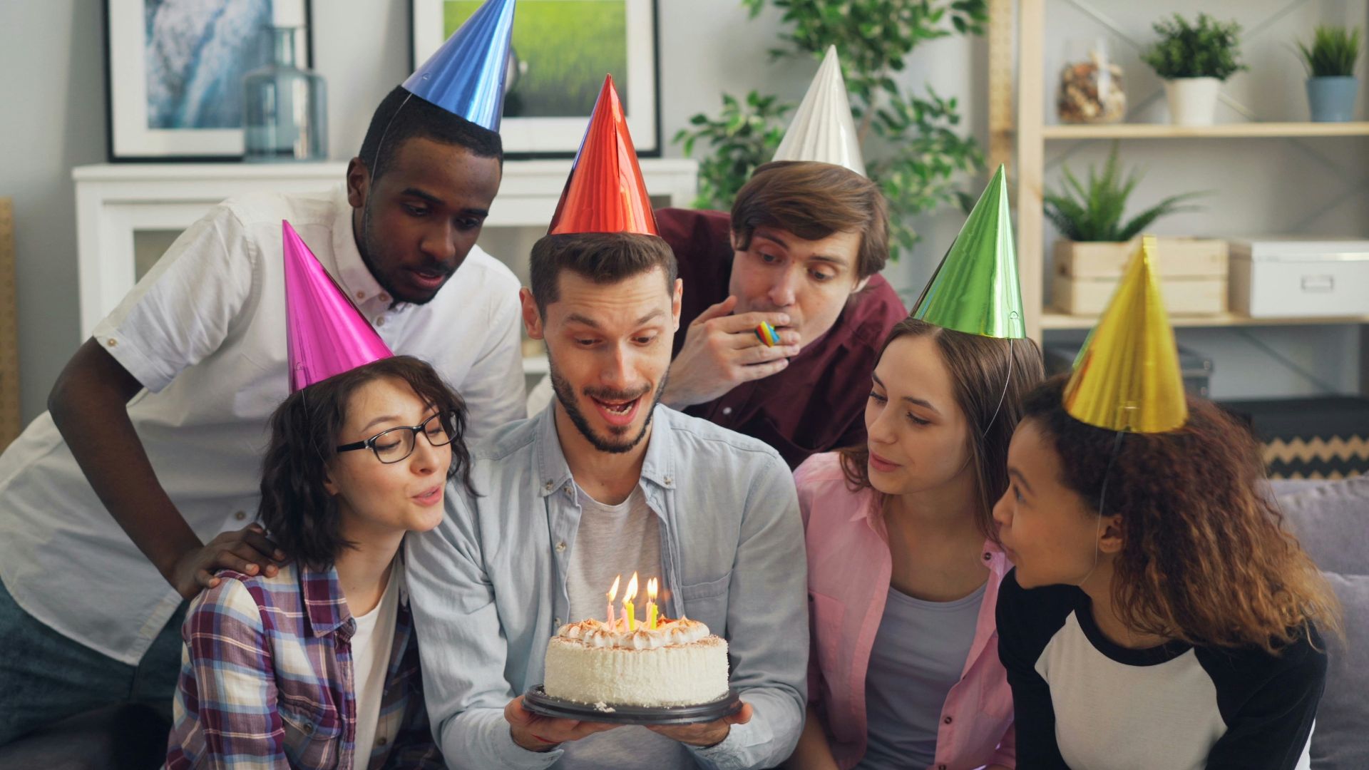 a group of people standing around a cake with candles on it