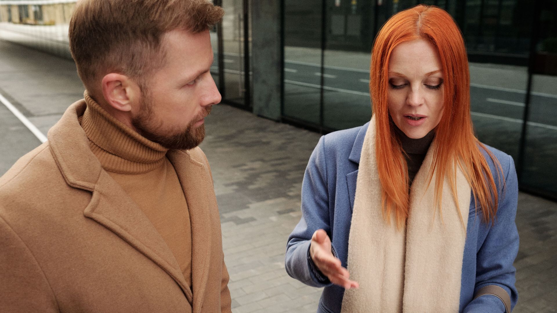 Two professionals engaged in a serious discussion, reviewing documents outdoors.