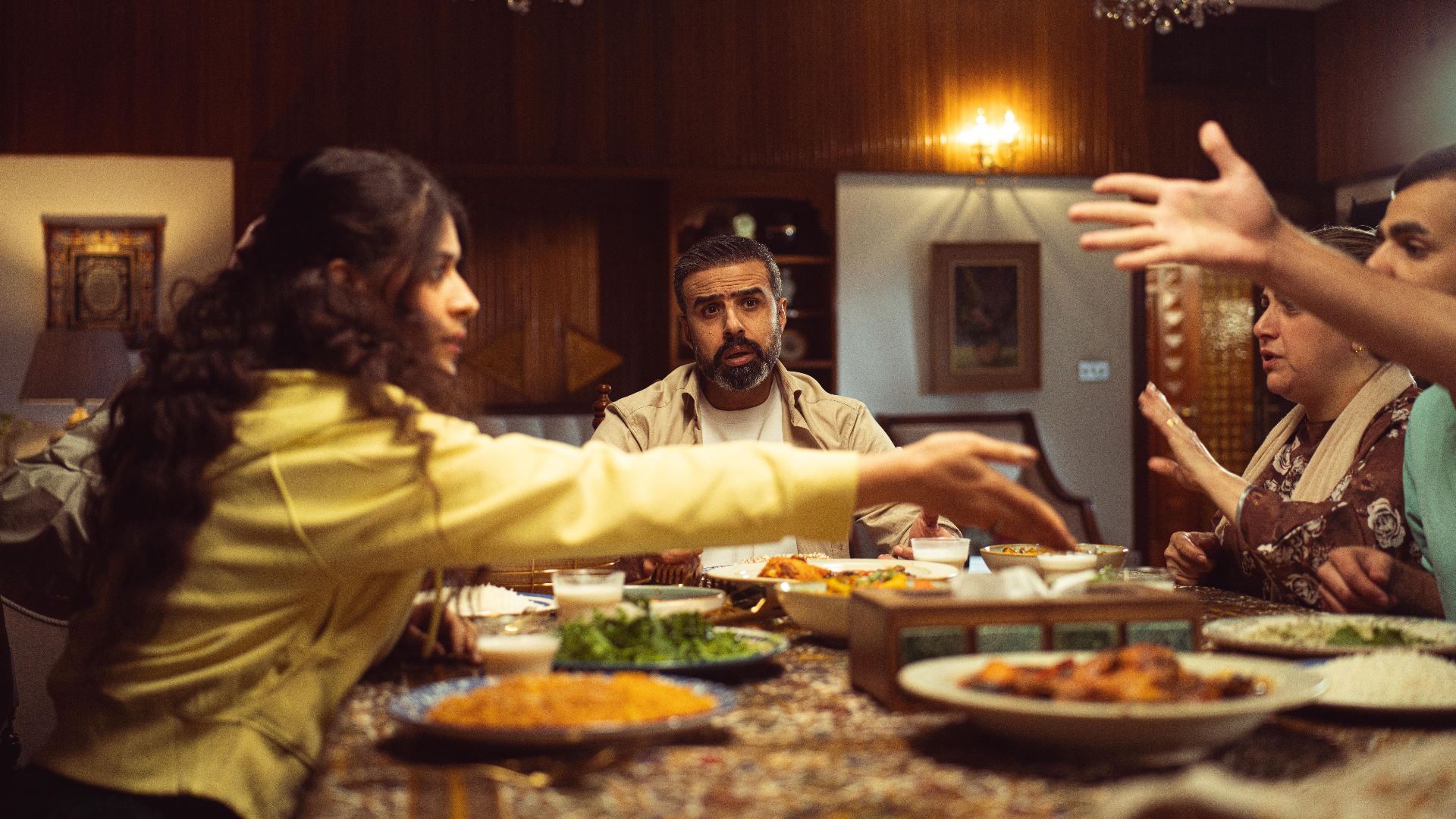 A lively family dinner with diverse group enjoying a meal and engaging in conversation.