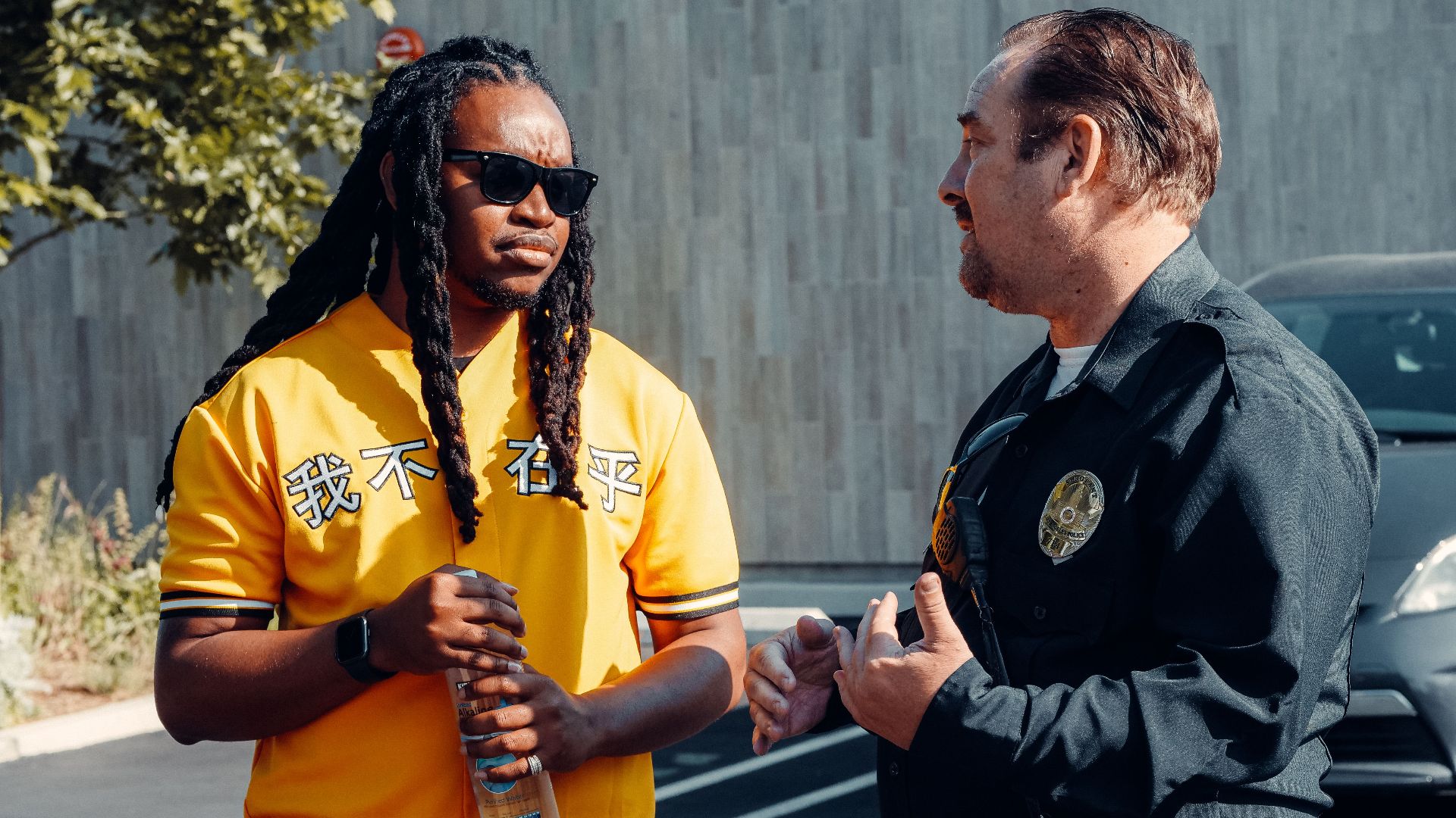 A police officer converses with a man in a casual urban setting, promoting community engagement.