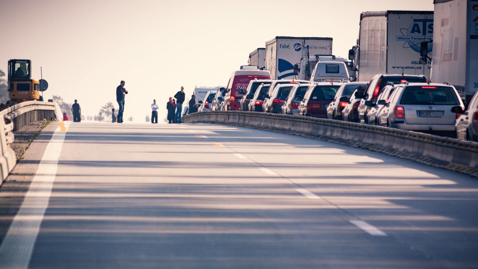A congested highway with cars and trucks in a traffic jam during daylight.