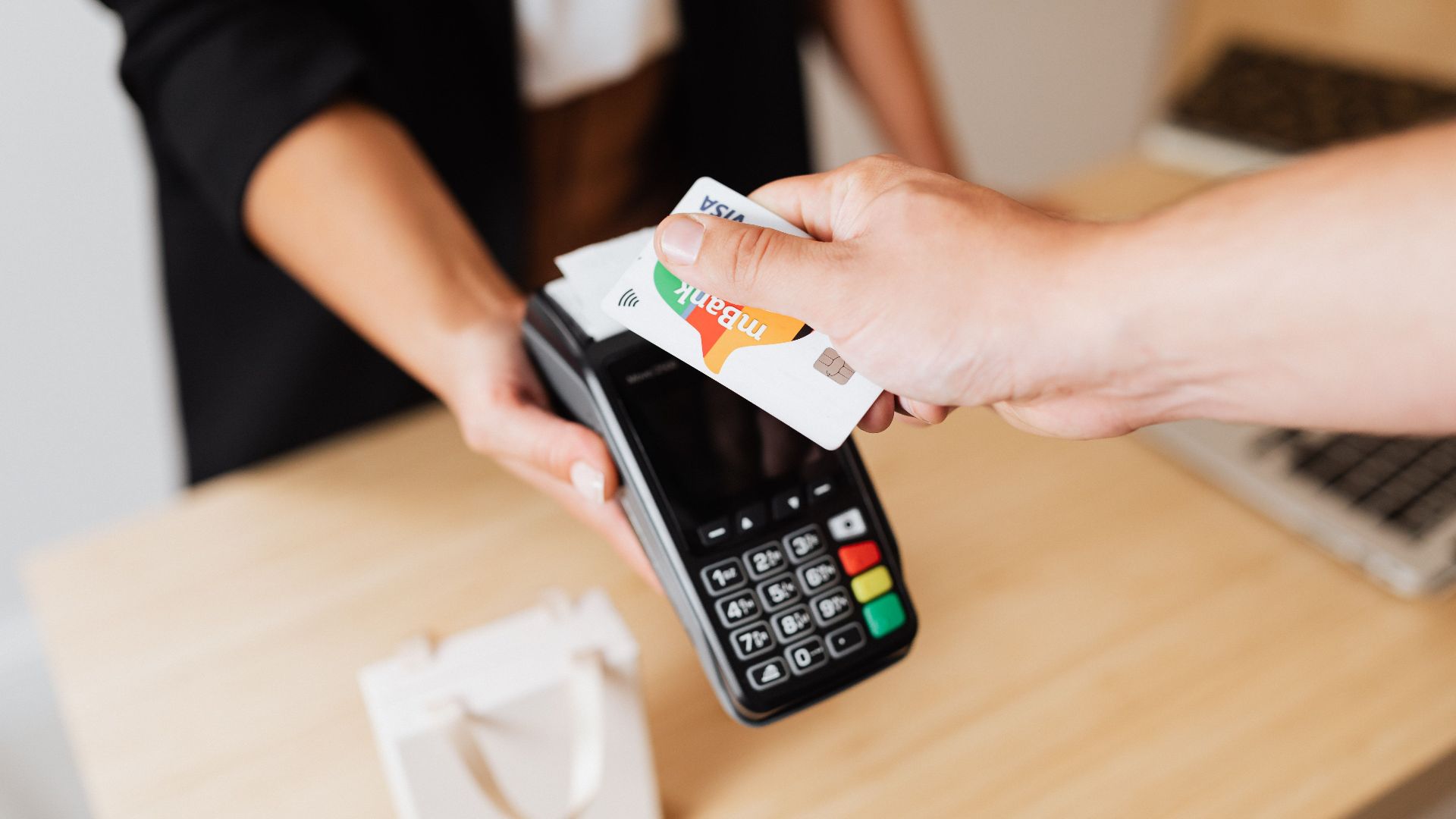 Close-up of contactless payment using a credit card at a modern POS terminal.