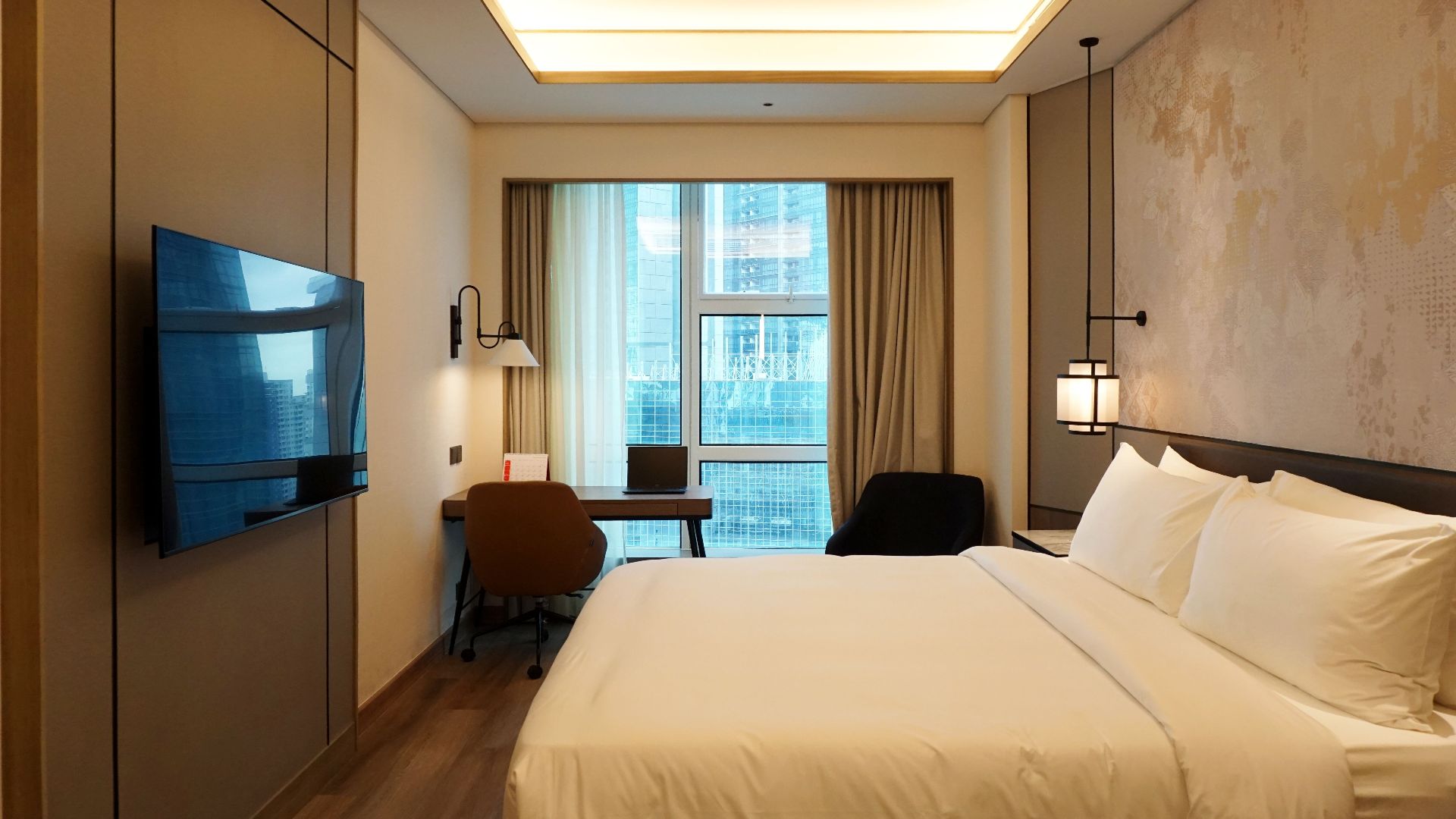 Cozy and stylish hotel room interior with city view in Jakarta, Indonesia.