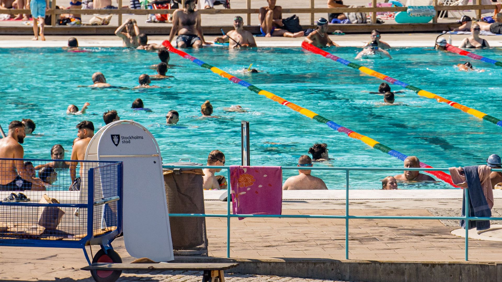 Crowds enjoying a sunny day at an outdoor swimming pool in Stockholm, Sweden.