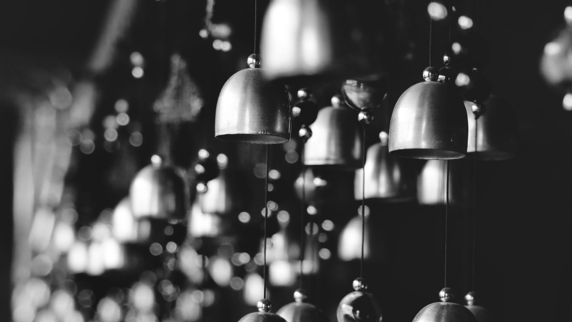 Monochrome photo of hanging bells in Darjeeling, India, creating shadows and light play.