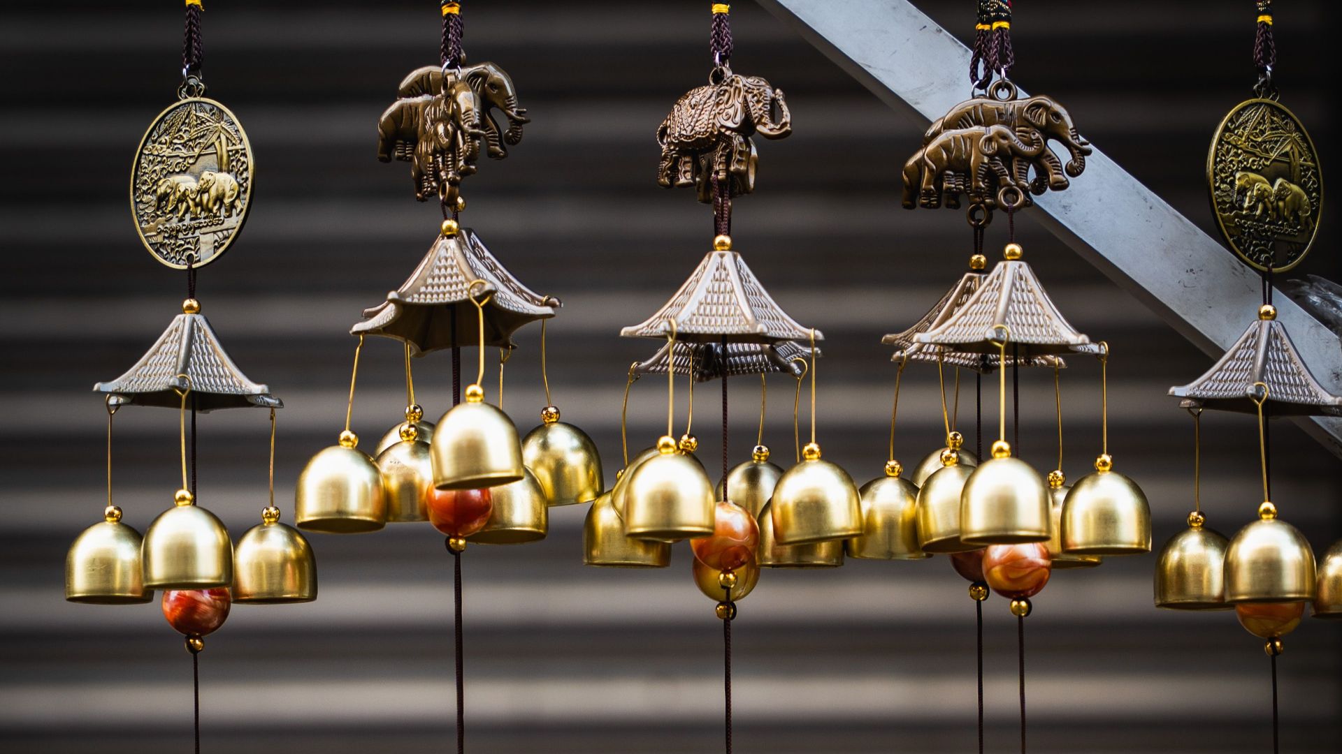 Detailed view of brass wind chimes with elephant motifs at a Sri Lankan market, showcasing intricate craftsmanship.