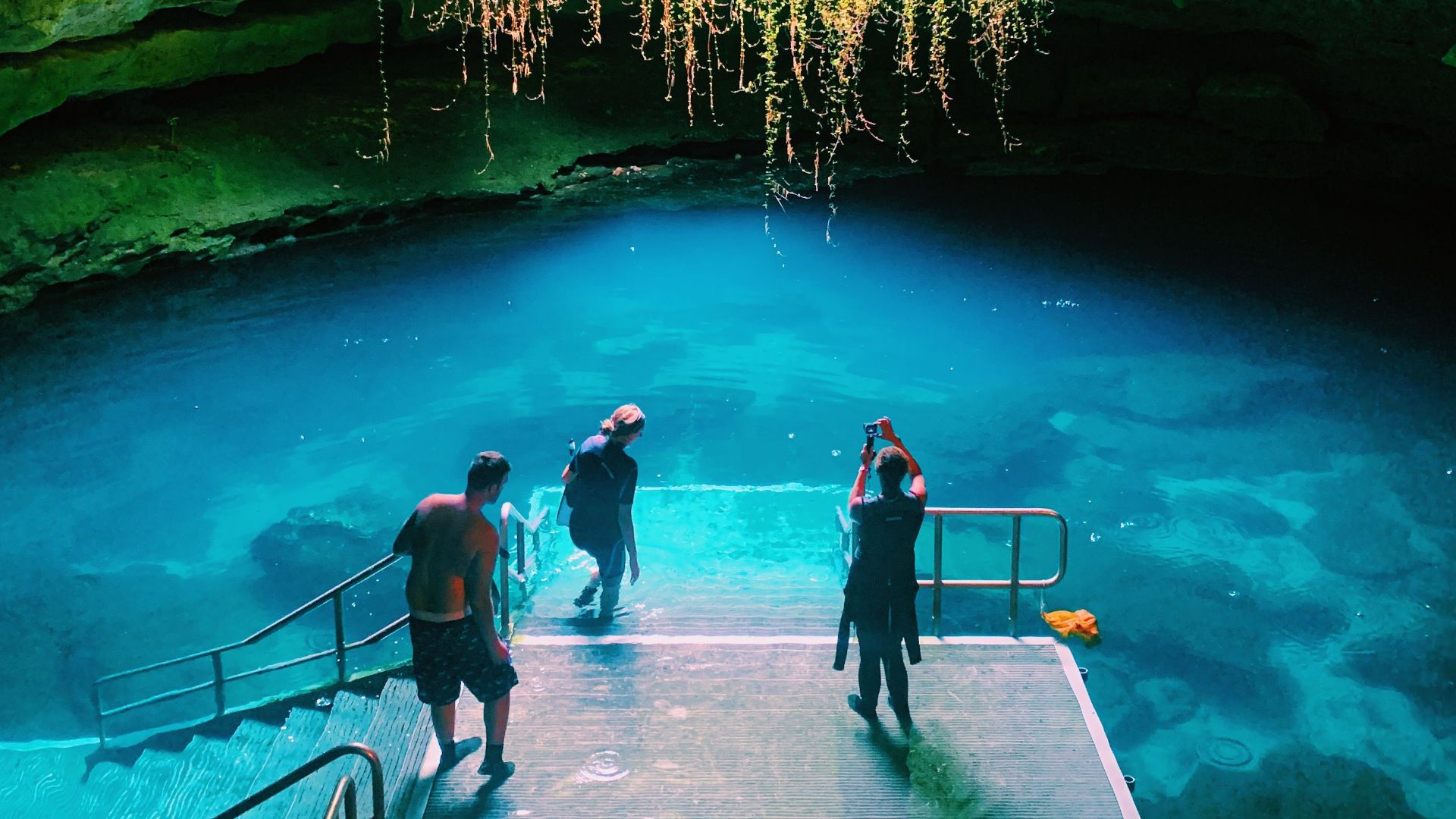 Dramatic view of Devil's Den Spring in Florida featuring vibrant waters and rock formations.