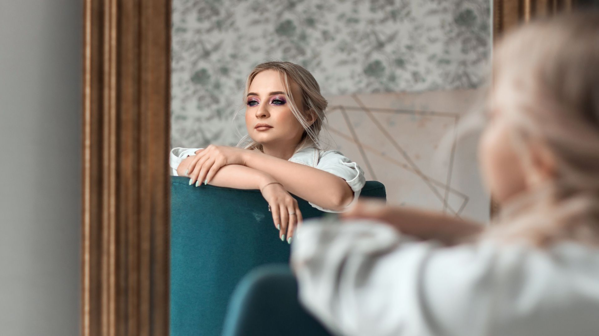 Elegant woman gazing into a mirror, creating a thoughtful and stylish composition.