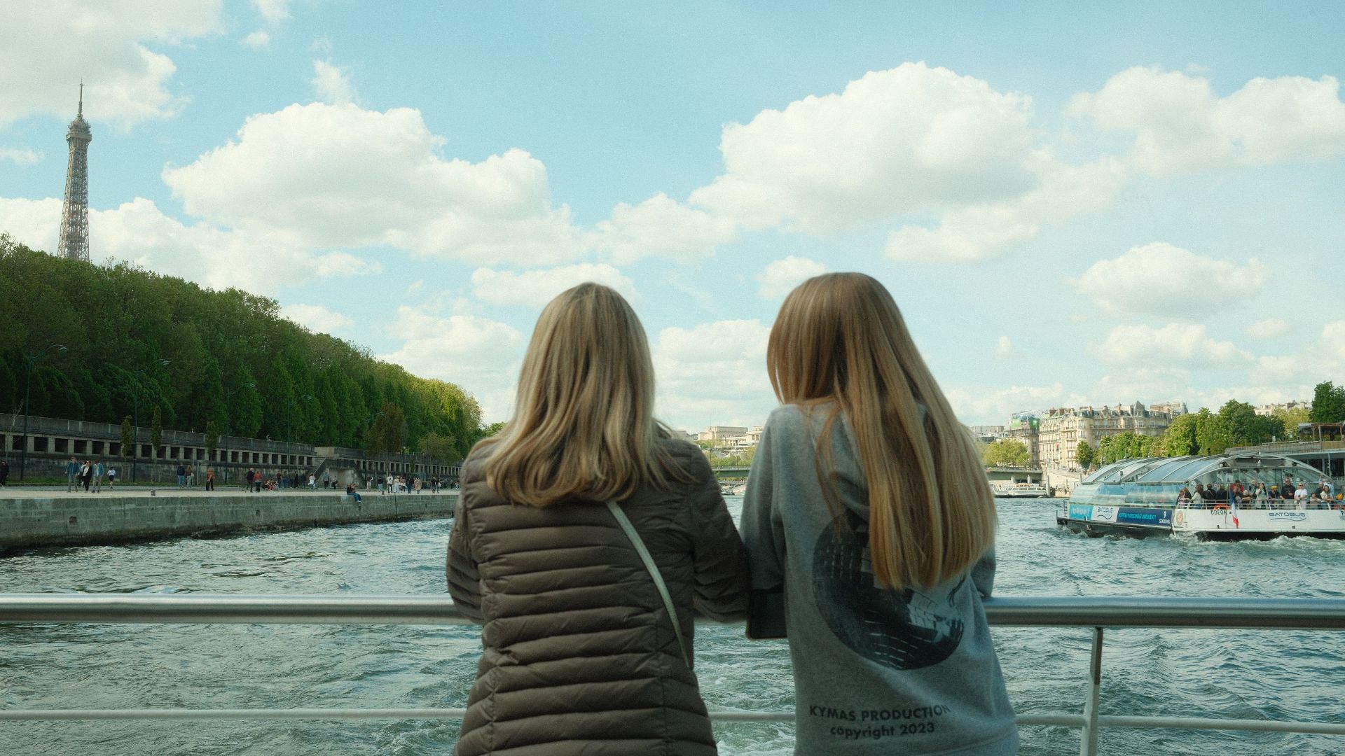 Two people enjoy a view of the Eiffel Tower from the Seine River in Paris, France.