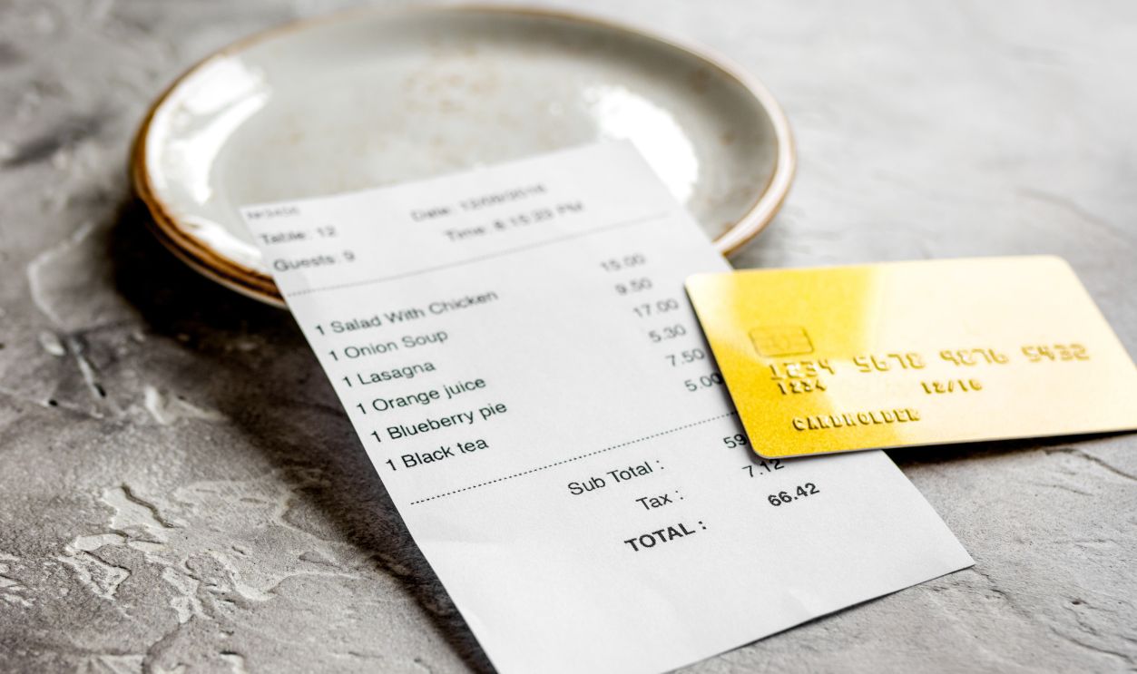 restaurant bill, card and plate on stone table background
