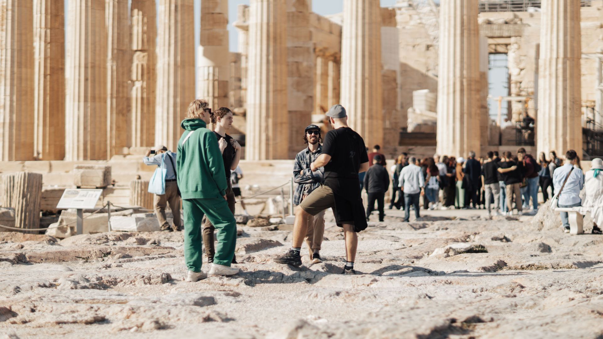 A group of tourists exploring the ancient ruins of the Parthenon in Athens, Greece.
