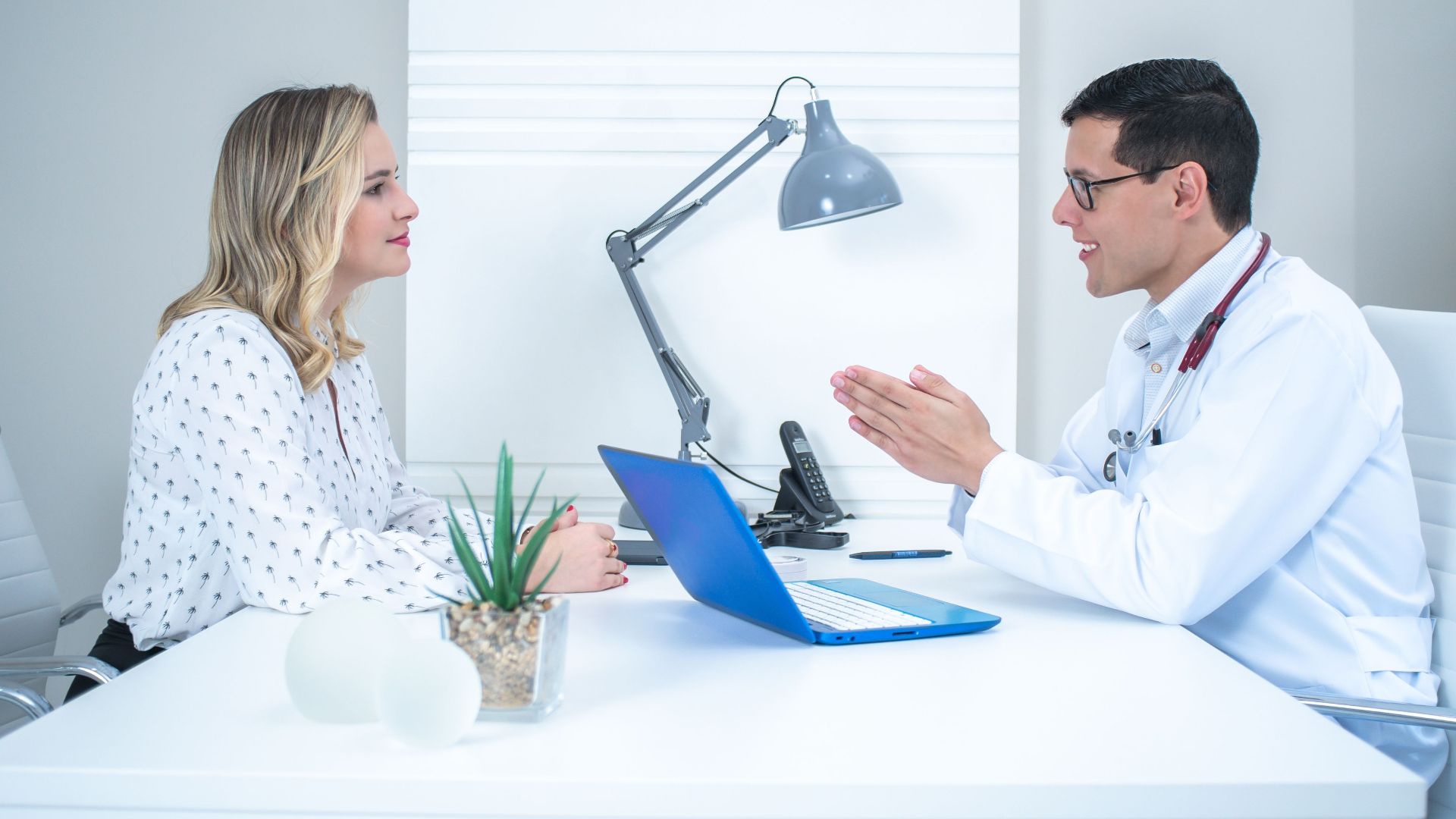 A doctor conducts a patient consultation in a bright, modern medical office.