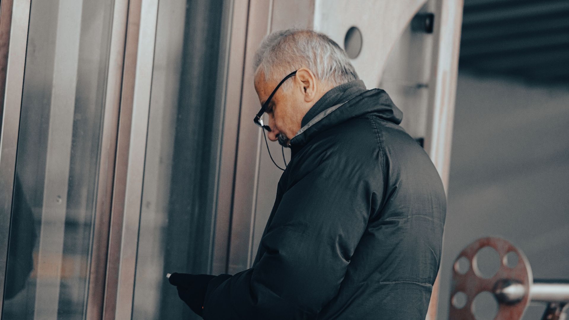 Senior man in winter coat waiting by elevator in Istanbul, Turkey.