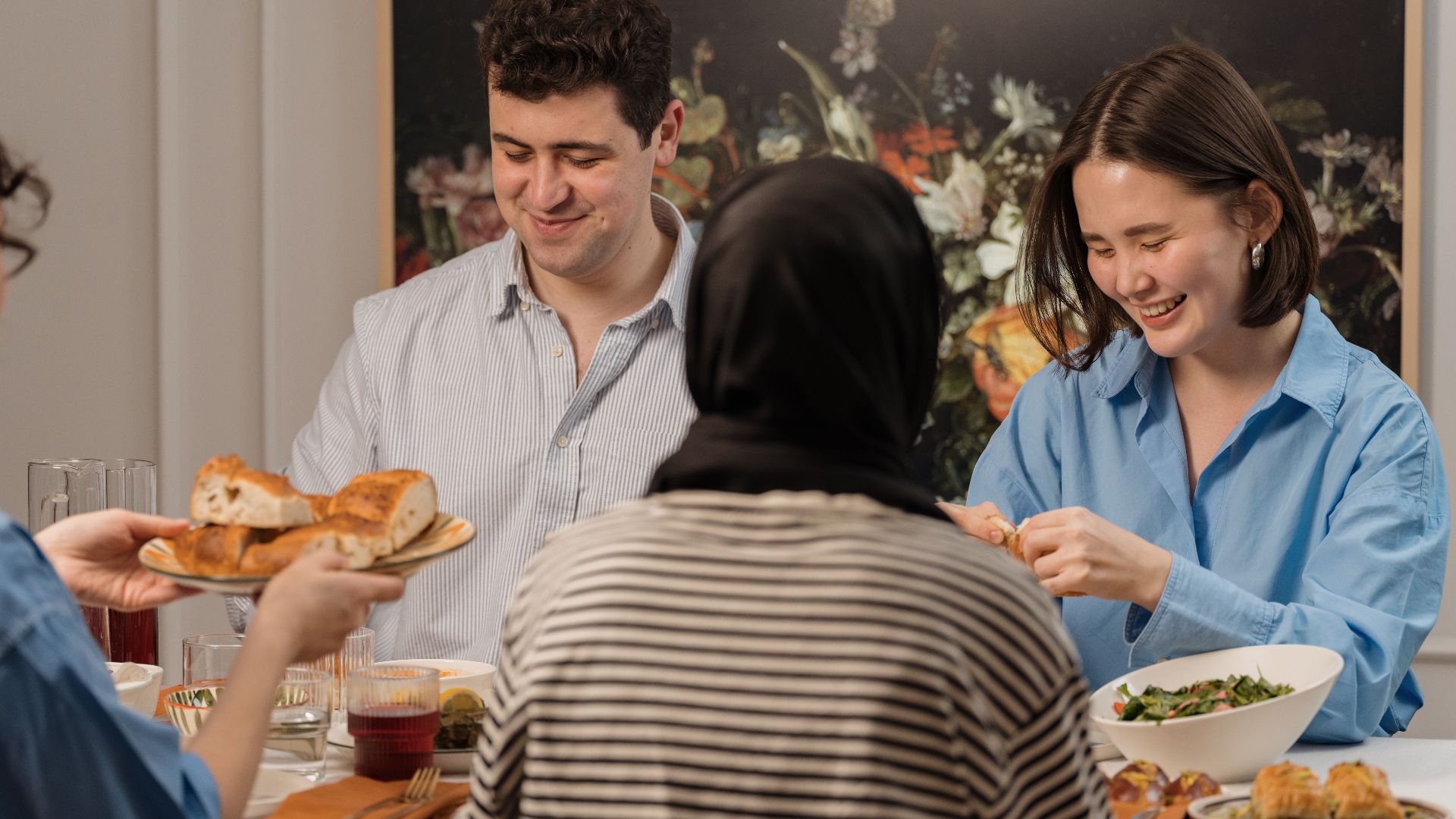 A cheerful group of friends enjoying a dinner party with delicious food and laughter.