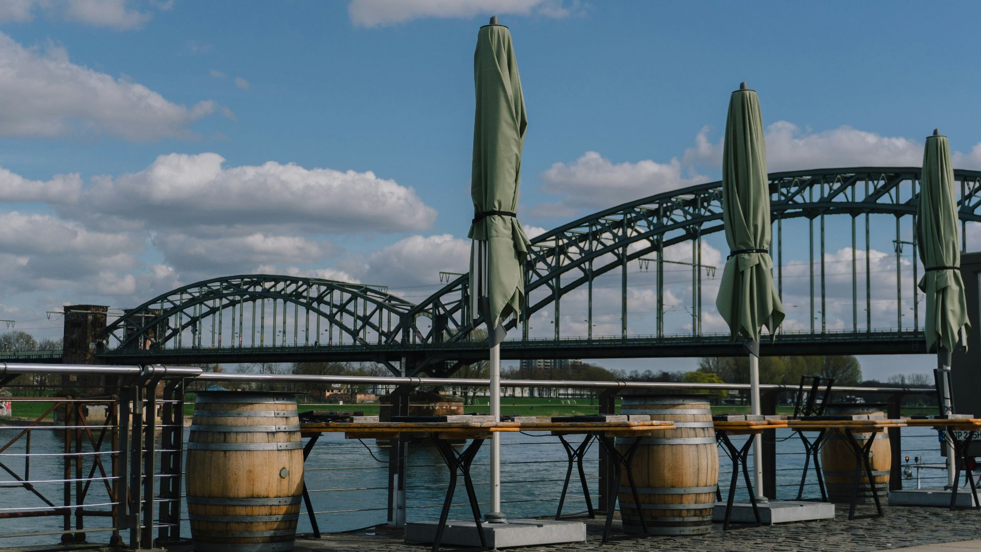 Outdoor seating area with closed umbrellas and barrels