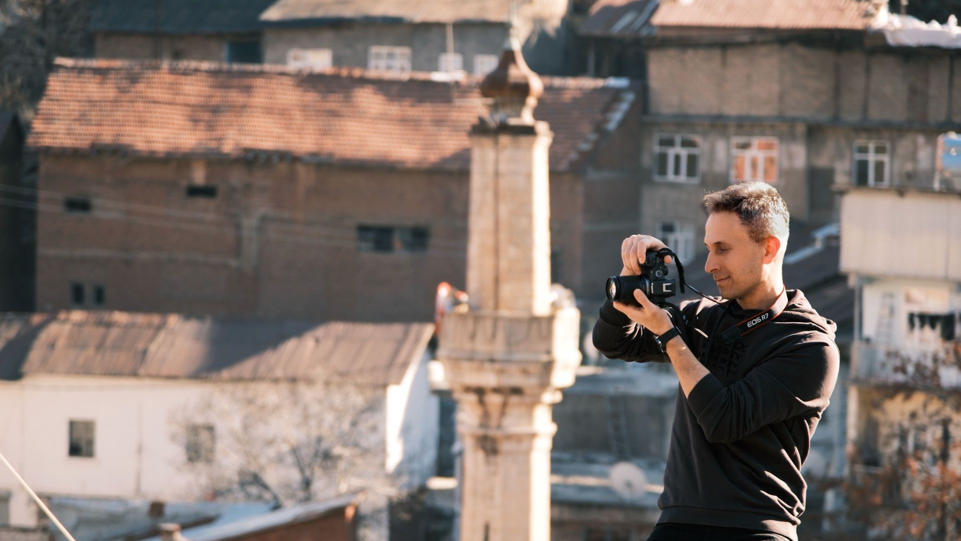 A photographer takes pictures in a historic urban area, capturing the city's essence.