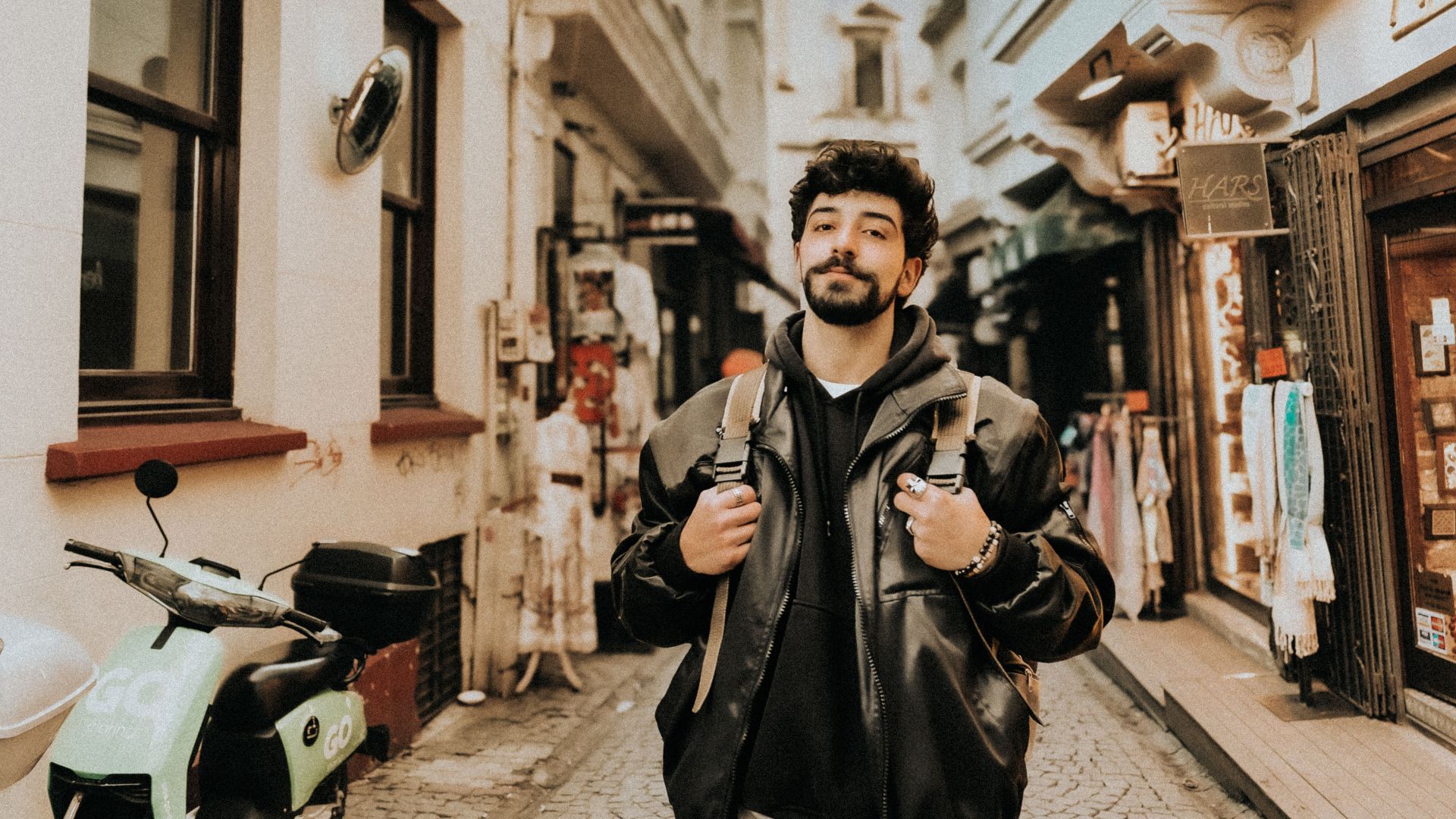 Casual young man with backpack strolling through vibrant Istanbul market.