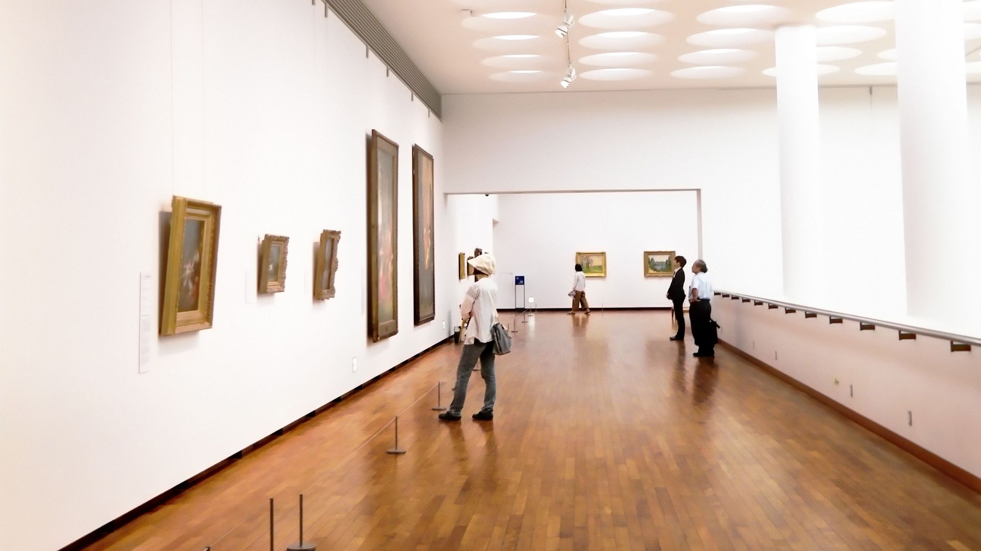 Explore a bright and airy art gallery featuring modern architectural elements and wooden floors.