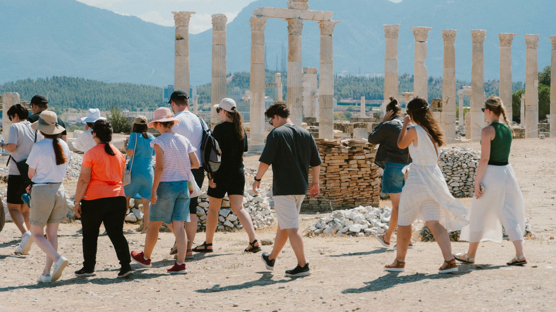 A group of people walking in front of some ruins