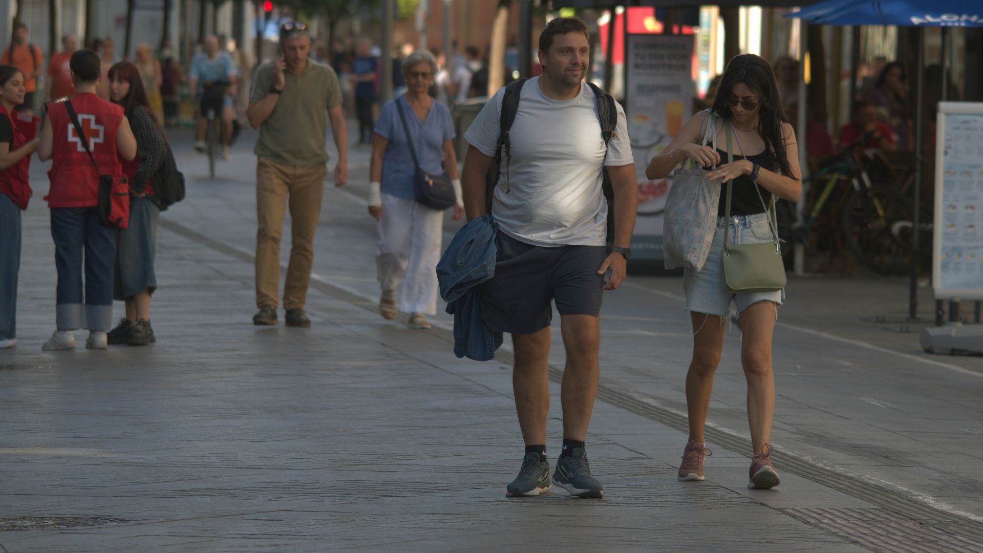 A group of people walking down a sidewalk