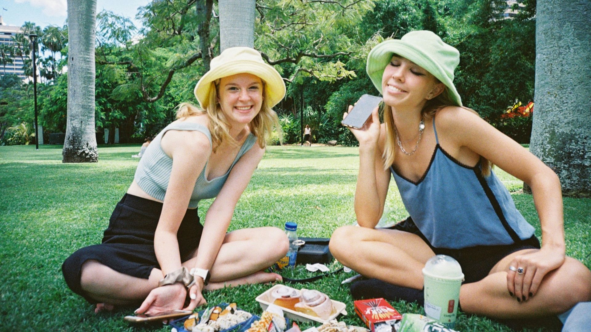 woman in black tank top sitting on grass field during daytime
