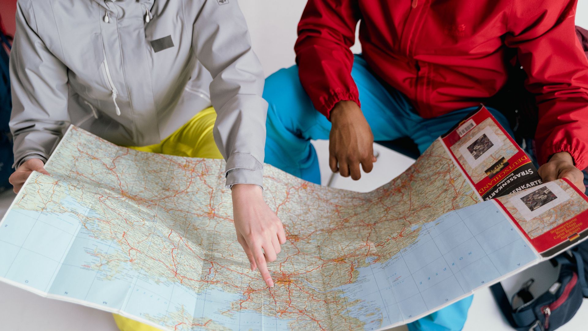 Two travelers examining a detailed map for a winter hiking adventure.