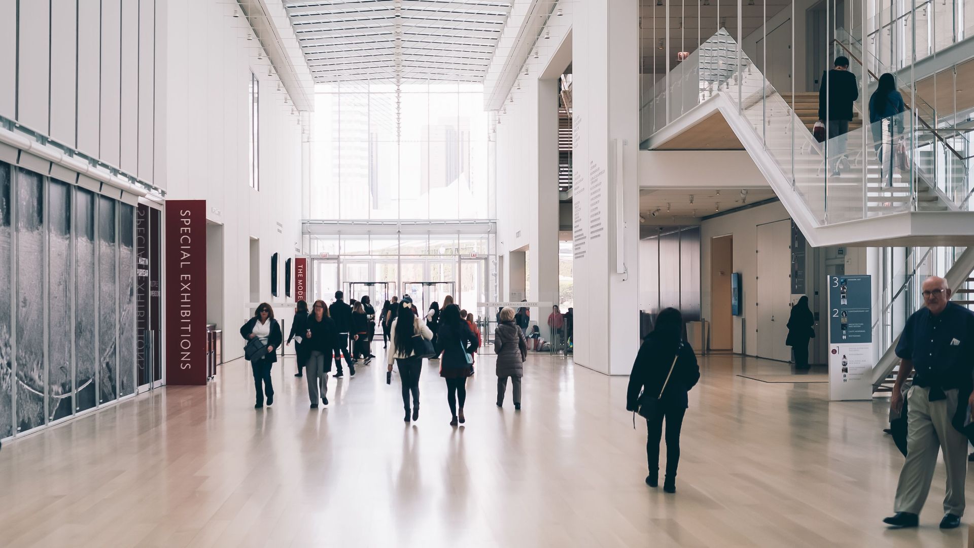 Spacious art gallery lobby with visitors in a modern architectural setting.