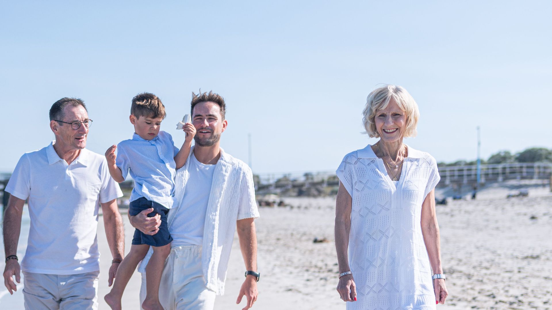 Happy multi-generational family enjoying a beach day together under the summer sun.