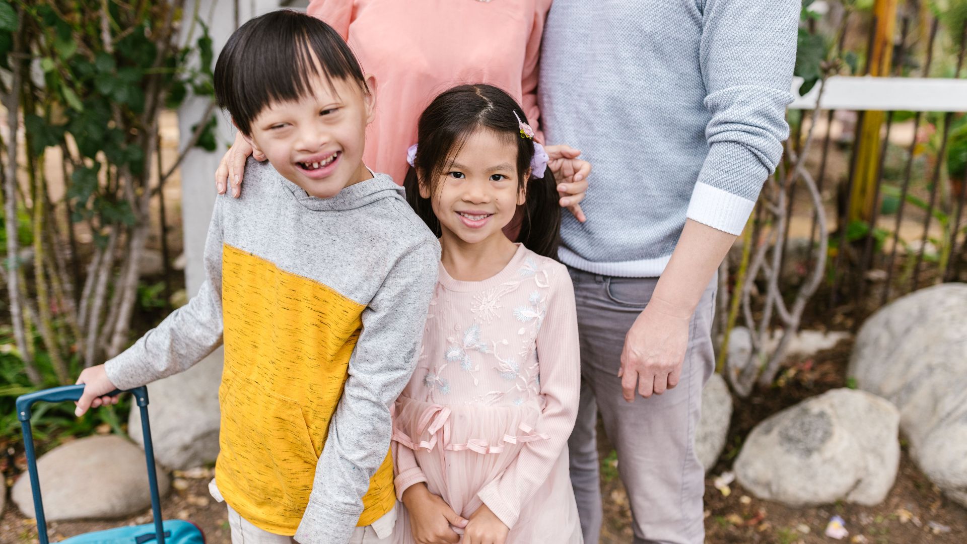 Joyful Asian family with smiling children enjoying a day outdoors, showcasing warmth and togetherness.