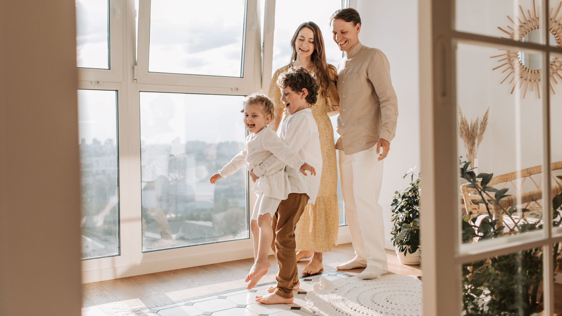 A joyful family of four enjoying time together in a bright, modern living room.