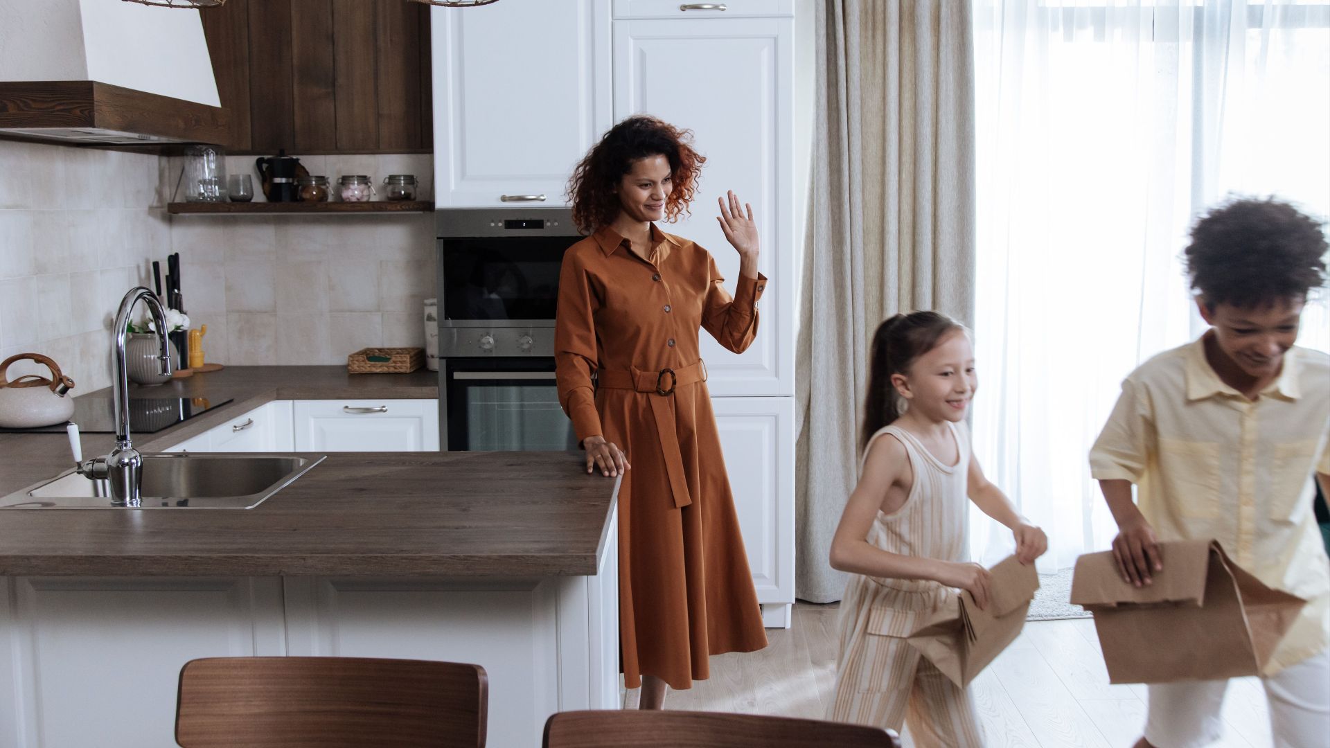Mother and children in kitchen, kids leaving with lunch bags.