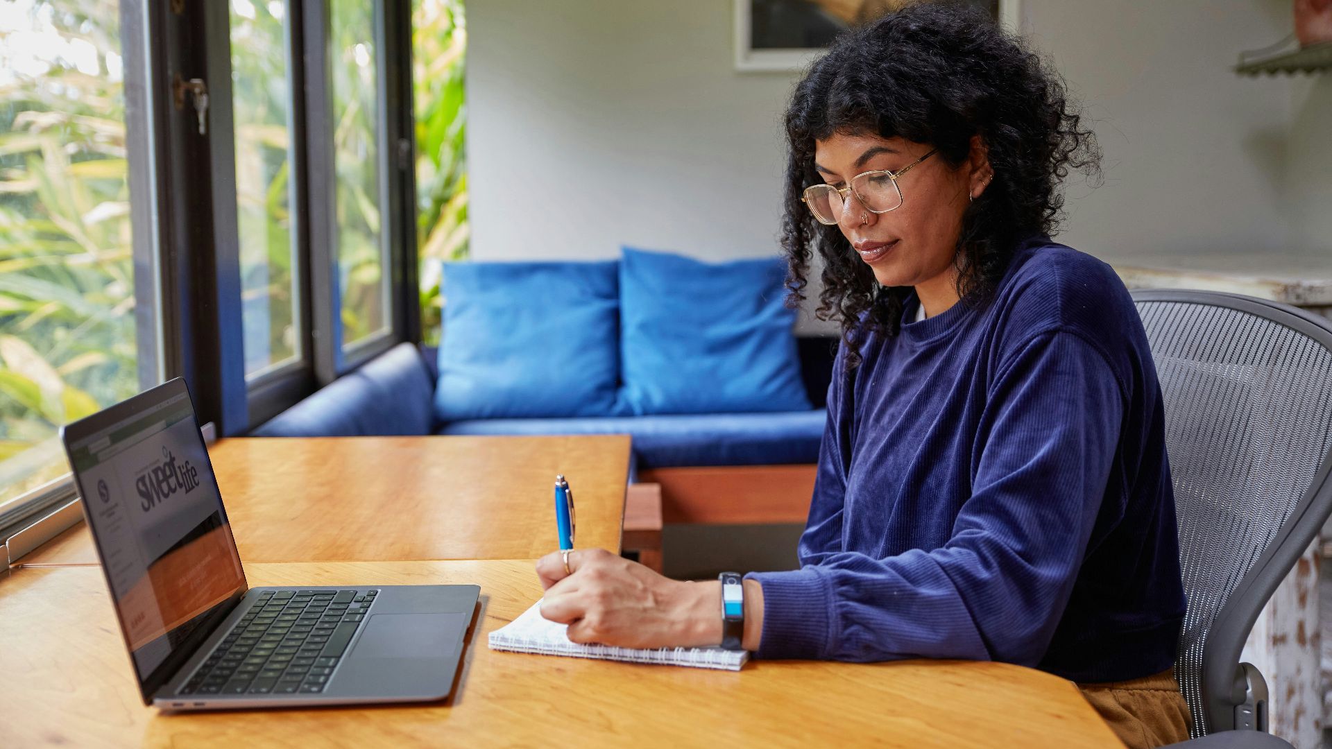 a woman sitting at a table with a laptop