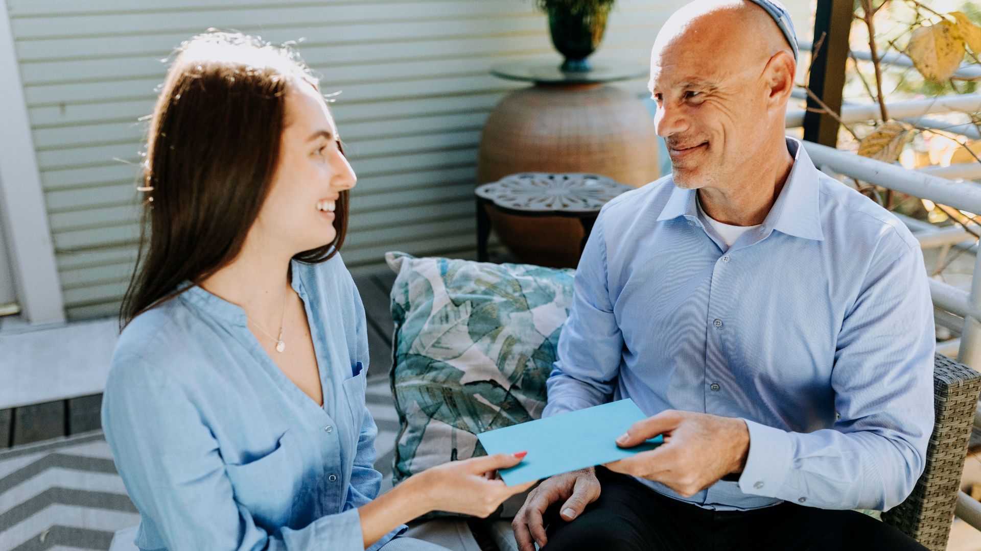 A father and daughter exchange a card in a warm and happy setting, symbolizing love and togetherness.