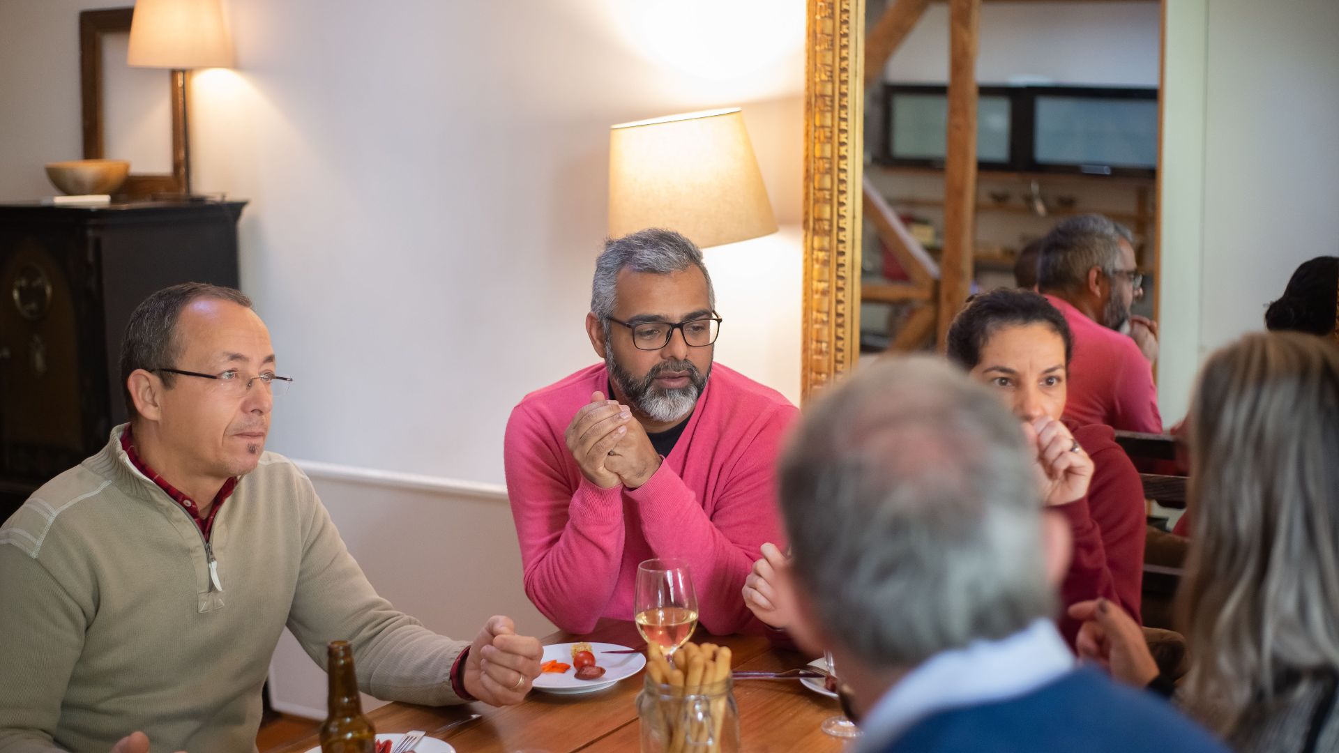 A family enjoying a casual meal indoors, sharing food and conversation.