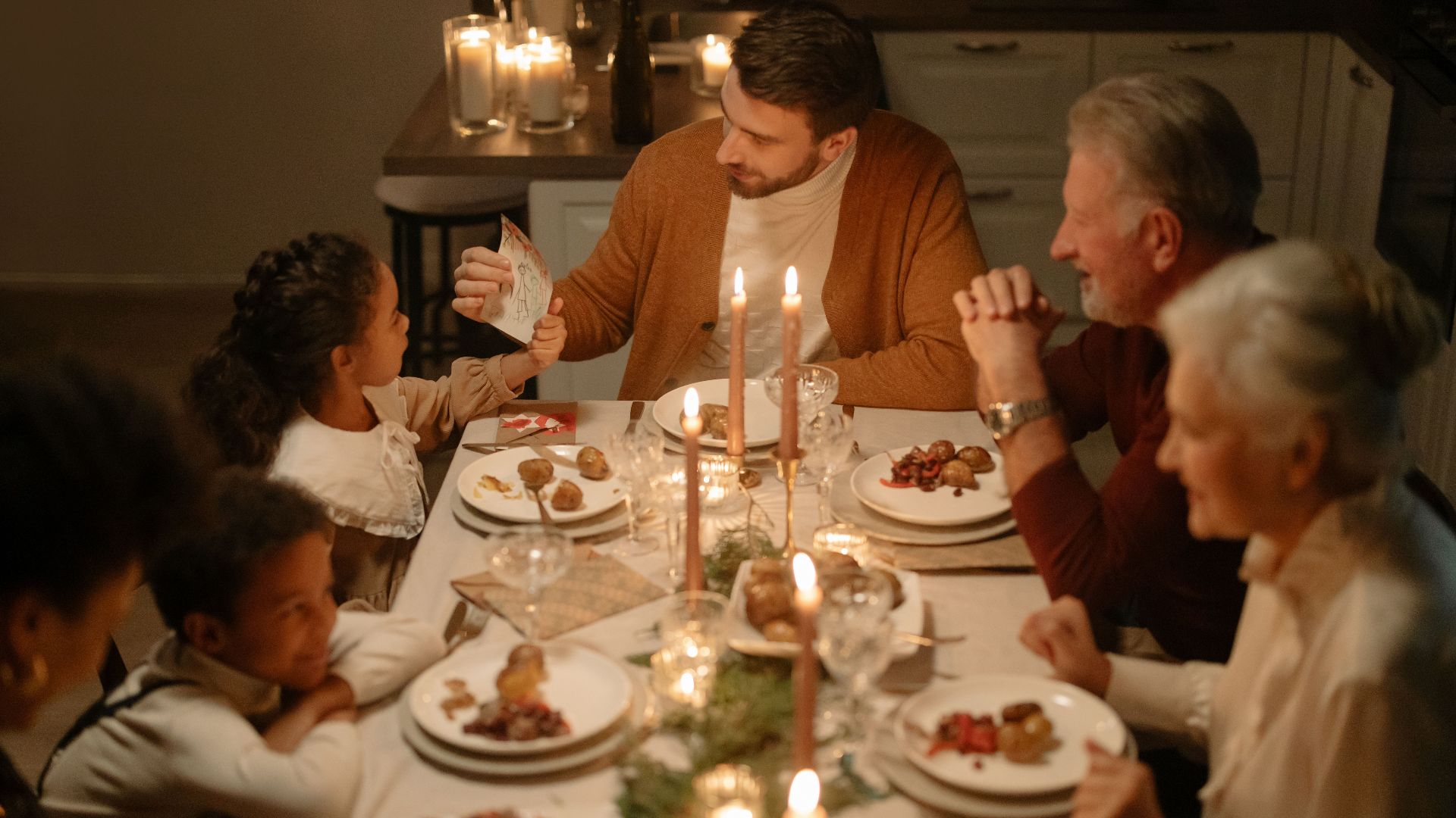 Warm and festive family dinner during Christmas with candles and joy.
