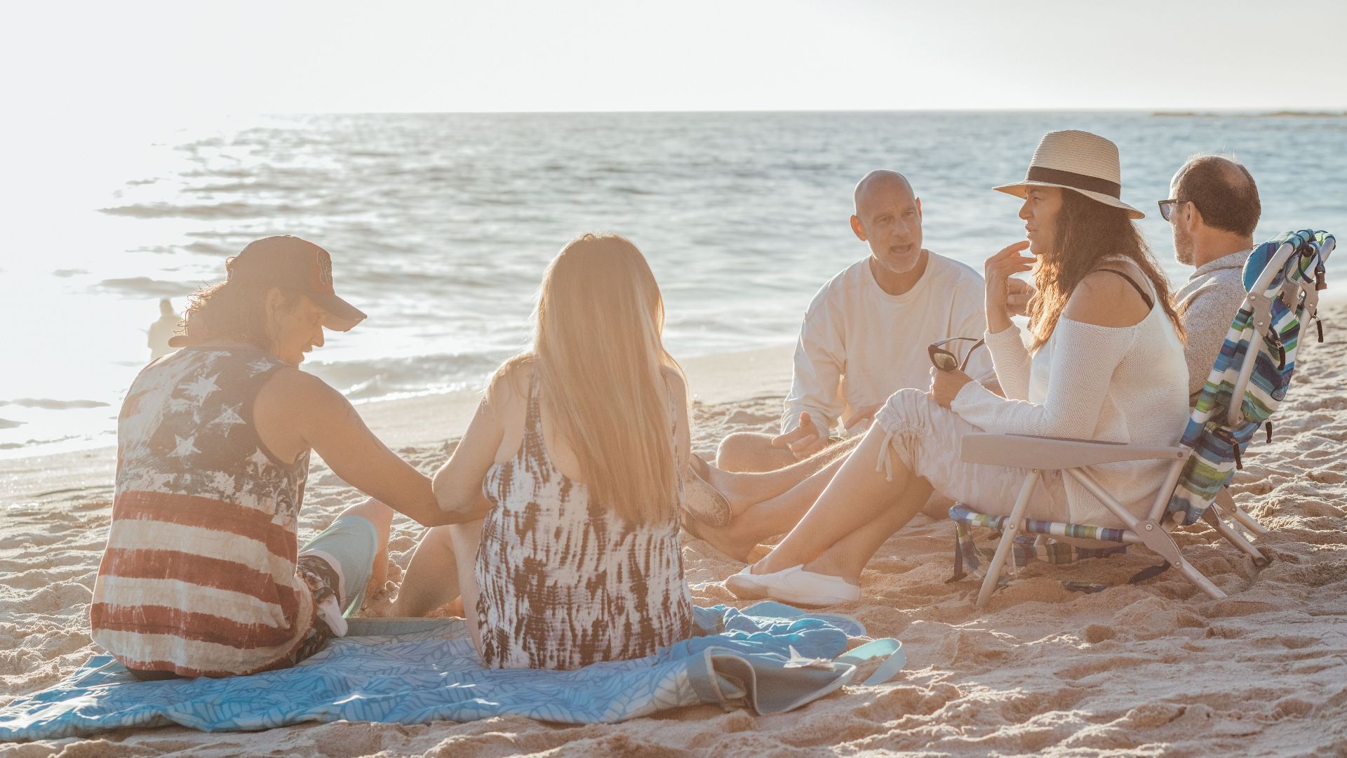A group of friends enjoying a sunny day together on a sandy beach.