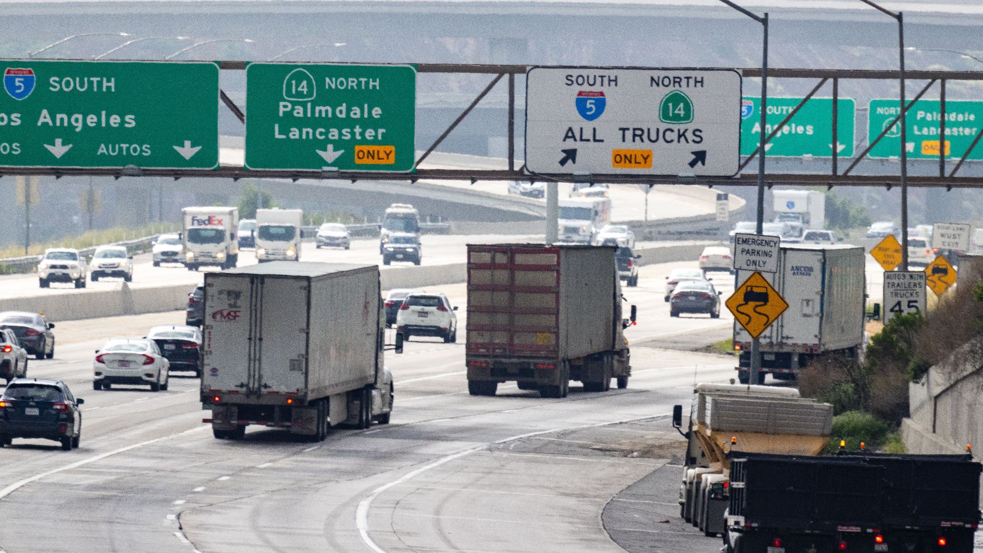 Traffic with trucks and cars on a highway in California heading to Los Angeles.