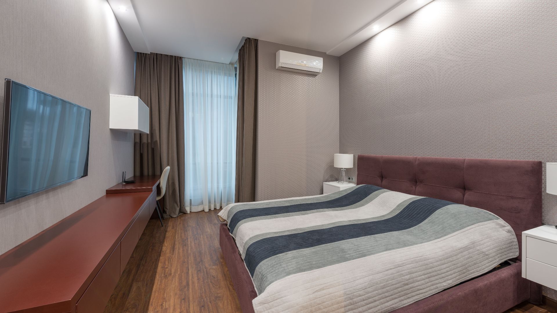 Elegant hotel room interior with a comfortable bed, modern furnishings, and a sleek design.
