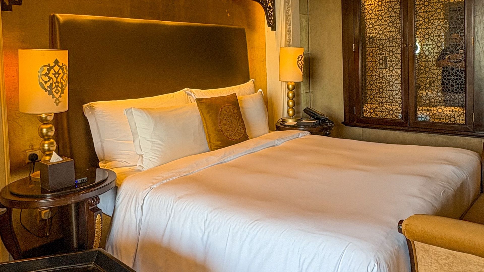 Elegant hotel room in Dubai with ornate decor and plush bedding.