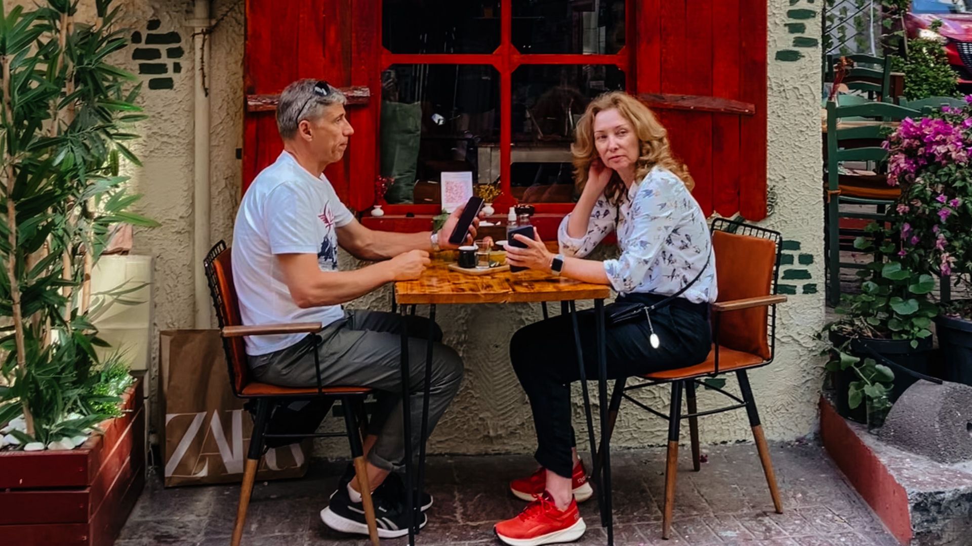 A couple enjoys a meal at Galata Süheyla, a cozy urban eatery with vibrant red decor.