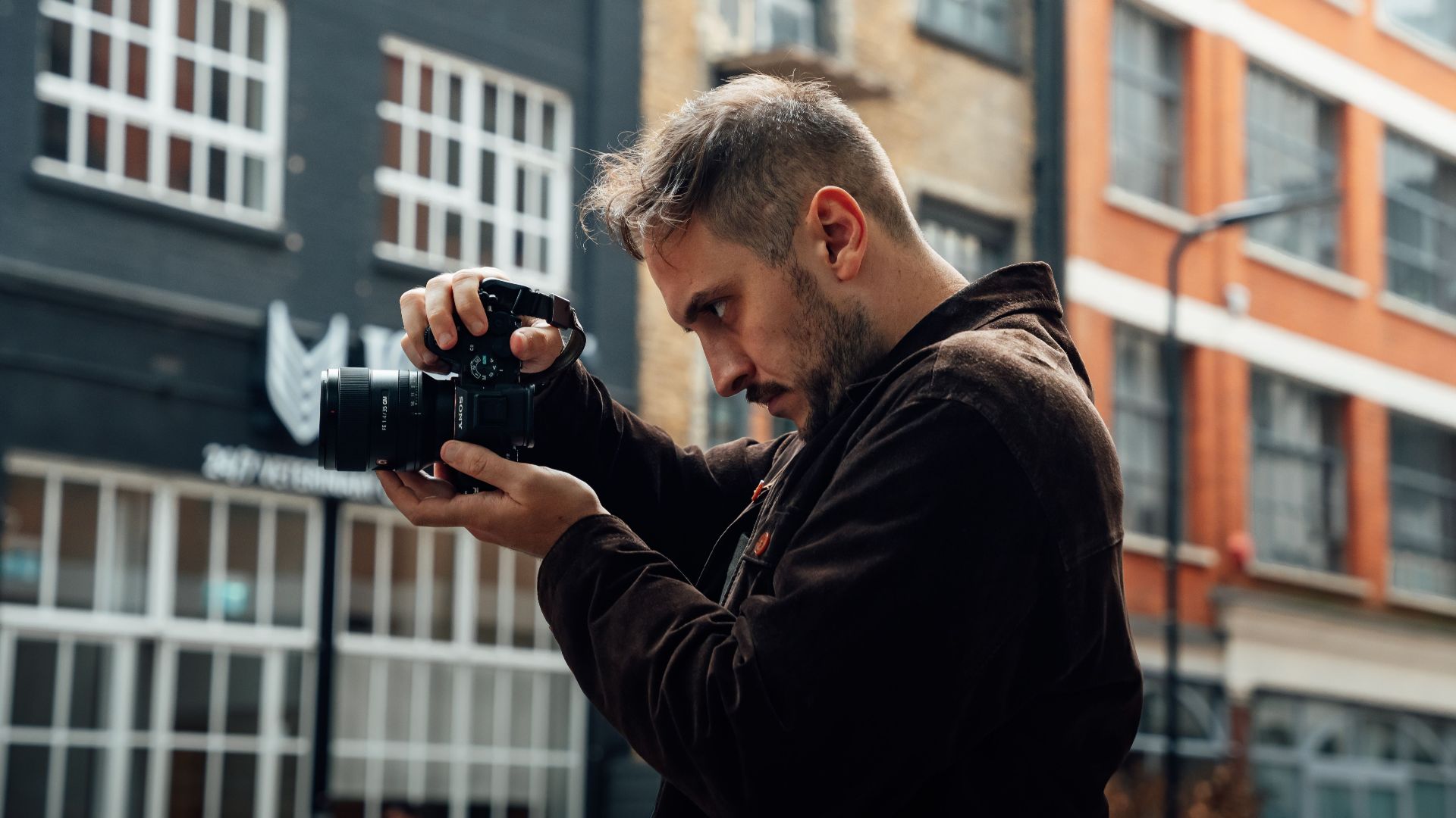 Photographer capturing urban street scene with buildings in London, UK.